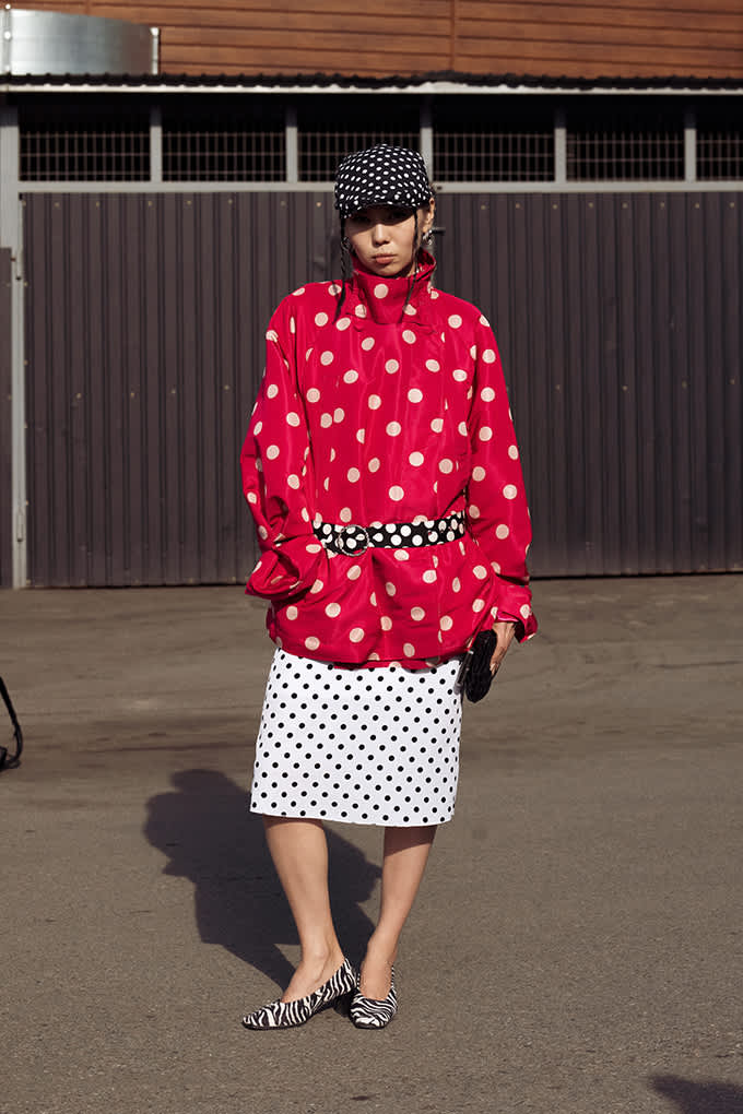 Frau trägt ein starkes Allover-Polka-Dot-Outfit mit Kopfbedeckung