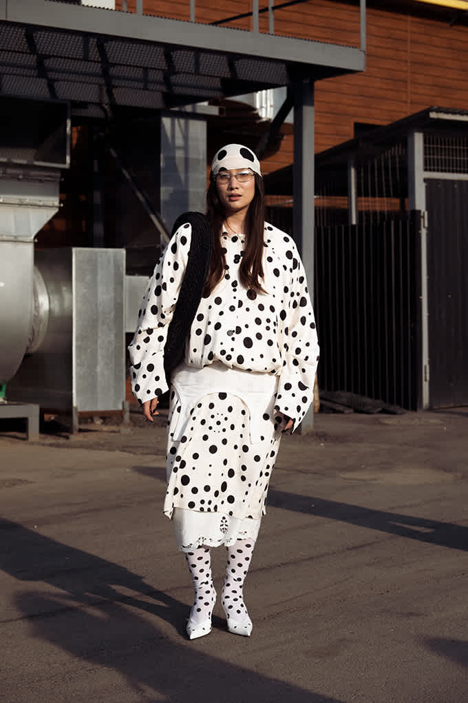 Frau trägt ein monochromes Allover-Polka-Dot-Outfit im ausgefallenen Stil