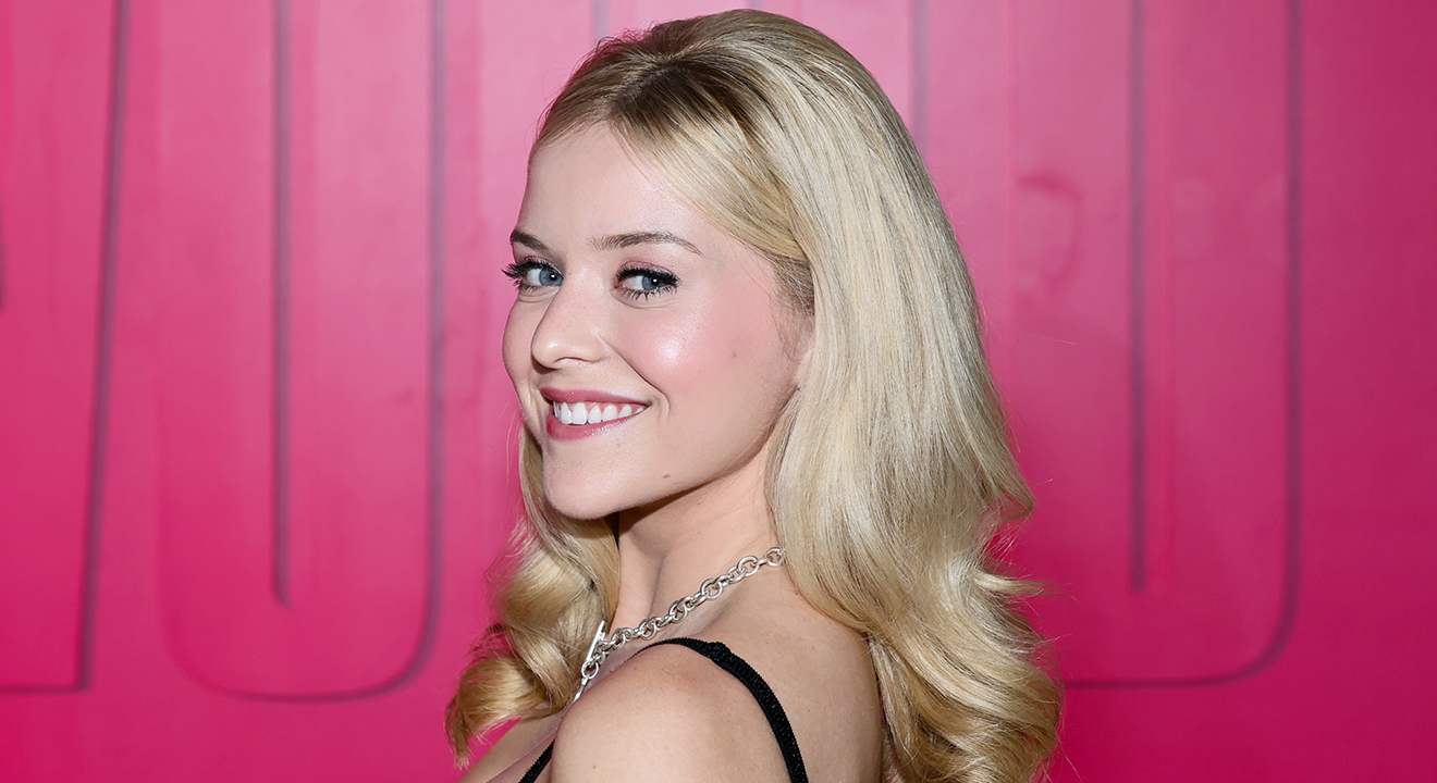Nahaufnahme Lexi Minetree als Elle Woods mit pinker Kulisse