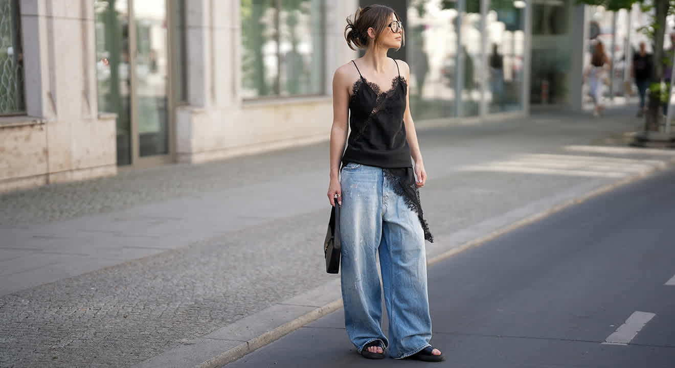 Junge Frau trägt Street-Style Outfit mit Baggy Jeans und schwarzem Camisole