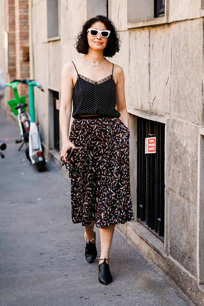 Frau trägt Outfit mit gemischten Mustern, Camisole-Top und Leoparden-Print-Hose 