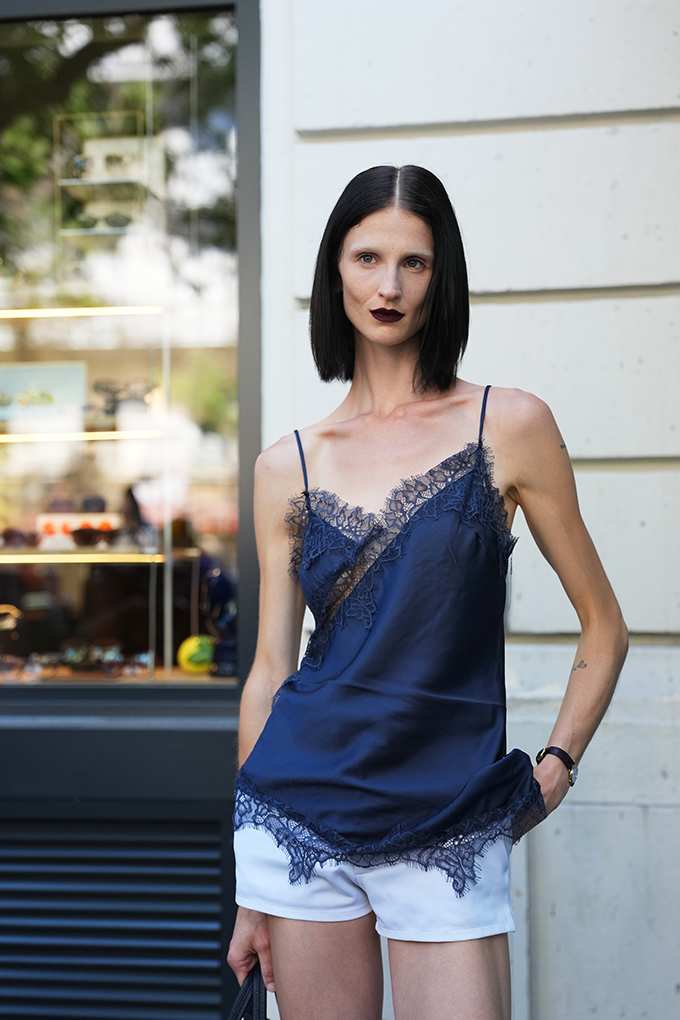 Frau zeigt Outfit, bei dem das elegante dunkelblaue Camisole das Center-Piece ist