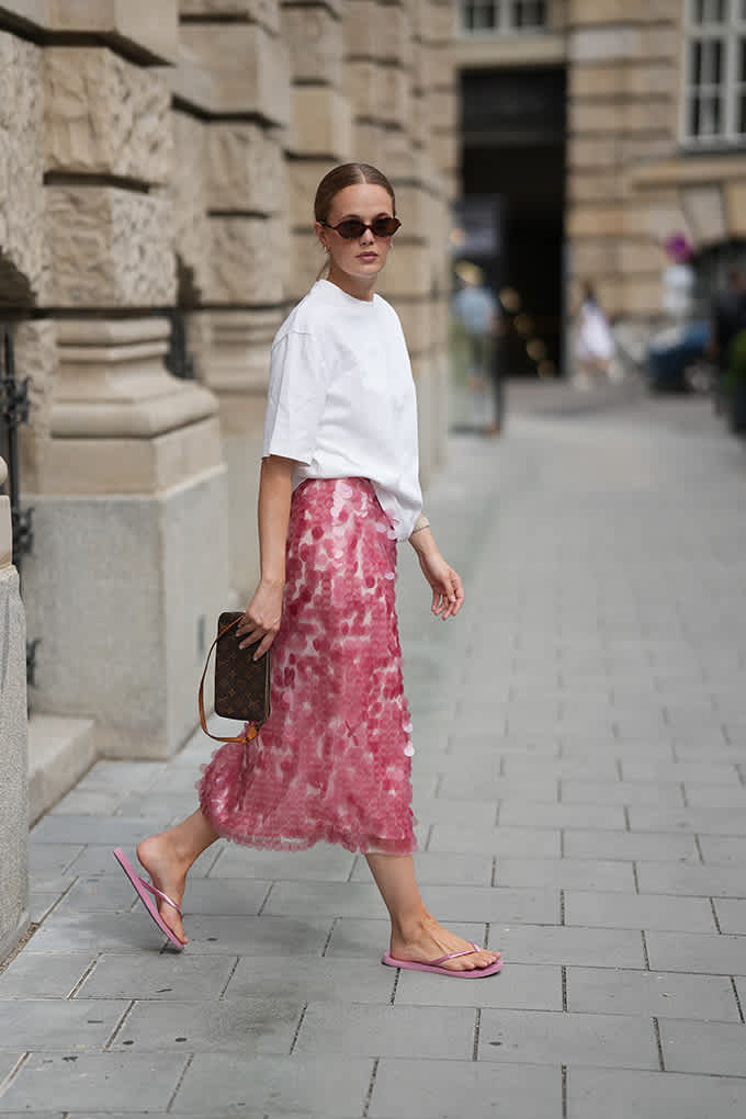 Frau trägt sommerliches Overzise-Outfit mit pinkfarbenen Zehentrennern