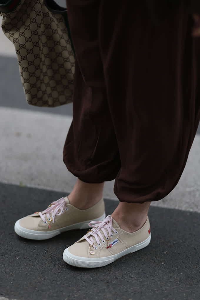 Beige Sneaker mit rosa Schnürsenkeln und brauner weiter Hose.