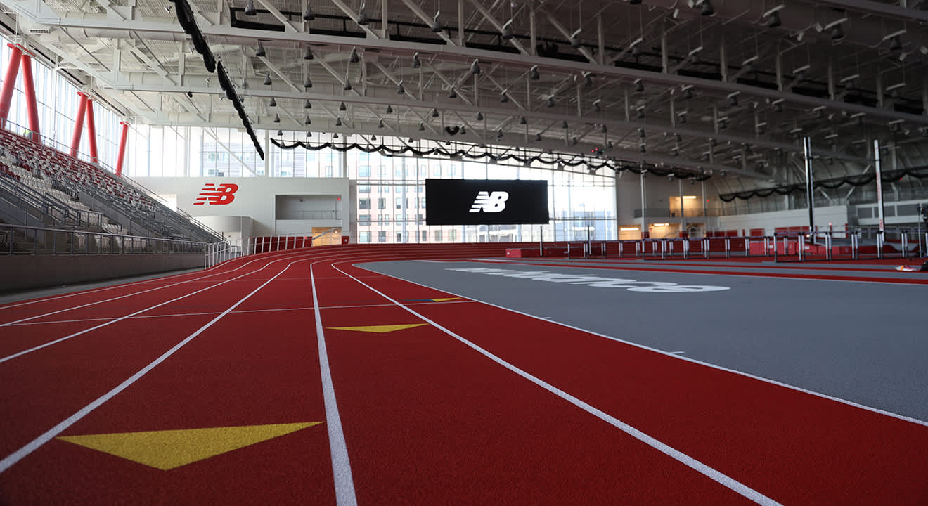 Leere Indoor-Laufbahn mit New-Balance-Logo in moderner Sportarena