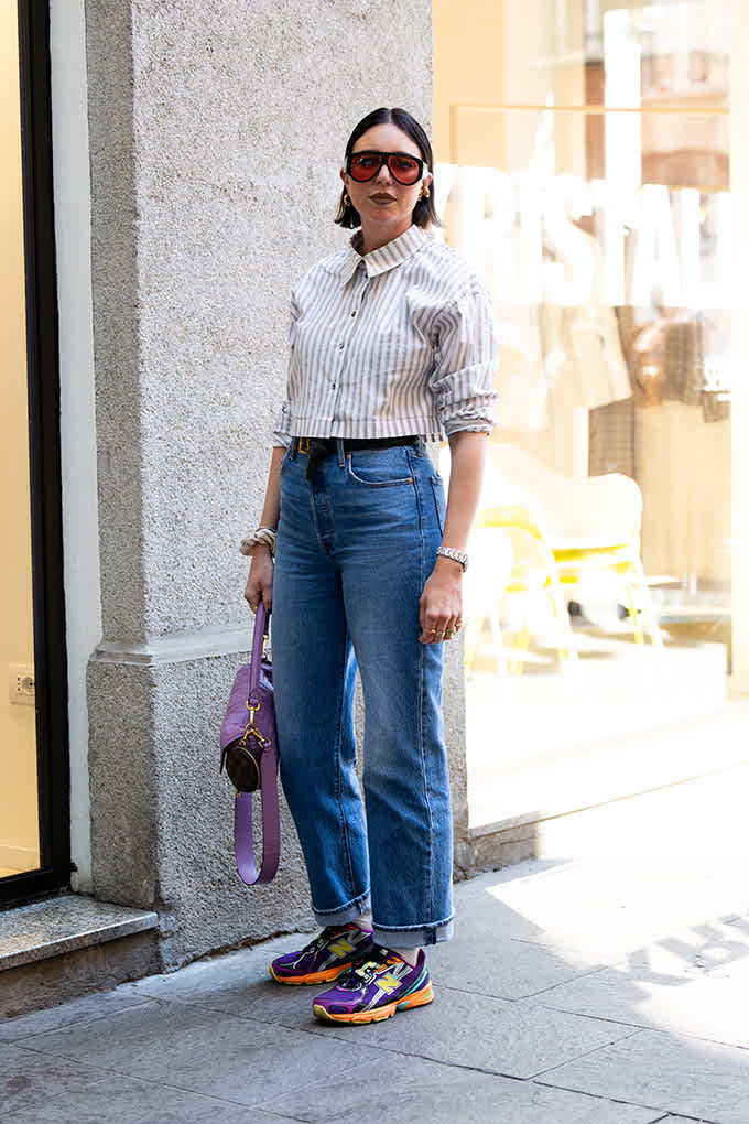 Streetstyle-Look mit gestreifter Bluse, Jeans und lilafarbenen New-Balance-Sneakern