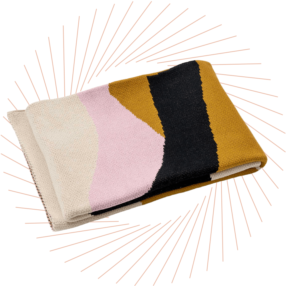 Gefaltete Strickdecke mit geschwungenem Colourblock-Muster in Creme, Rosa, Schwarz und Senfgelb