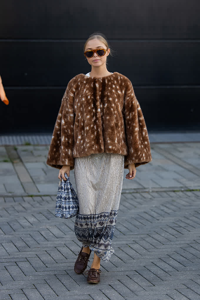 Streetstyle-Look mit Felljacke, Plisseerock mit Muster und braunen Schnürschuhen
