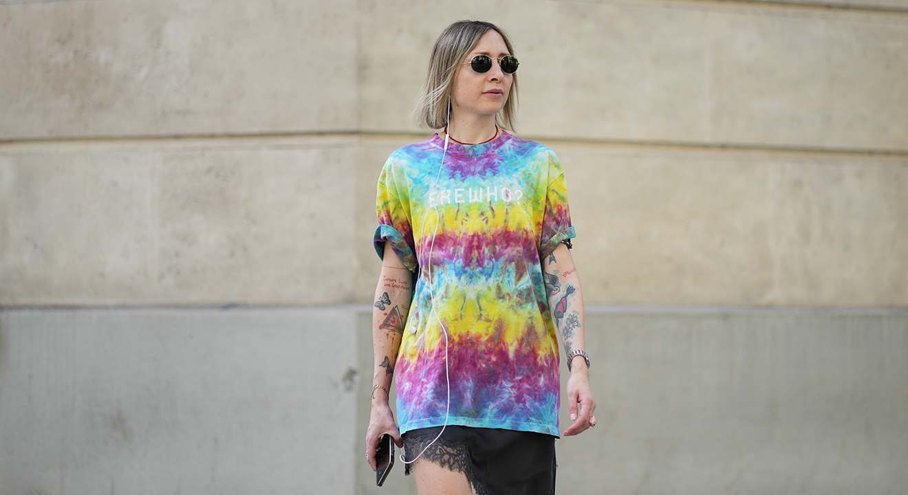Frau trägt mutig kombiniertes Outfit mit Regenbogen-Tie-Dye Shirt