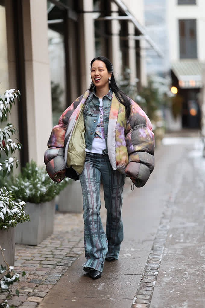 Frau in einem bunt gemusterten Tie-Dye-Outfit mit Jacke und Hose