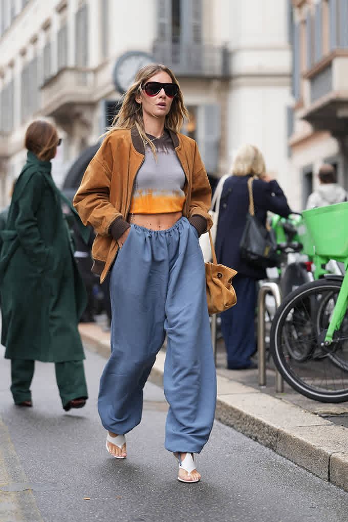 Frau in einem lässigen Tie-Dye-Crop-Top mit orangefarbenem Farbeffekt