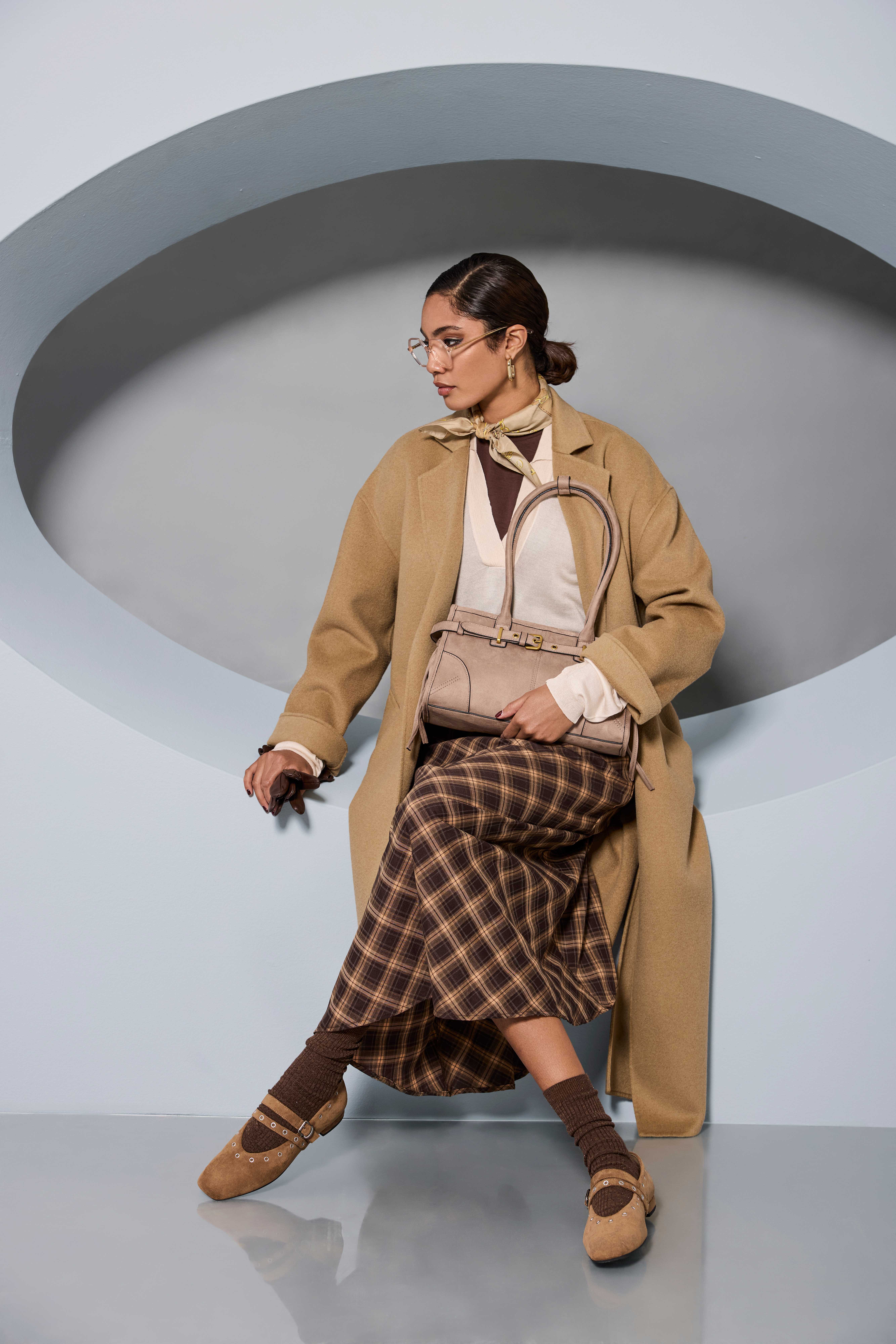 Frau im eleganten Business Look mit Trenchcoat und Karorock.