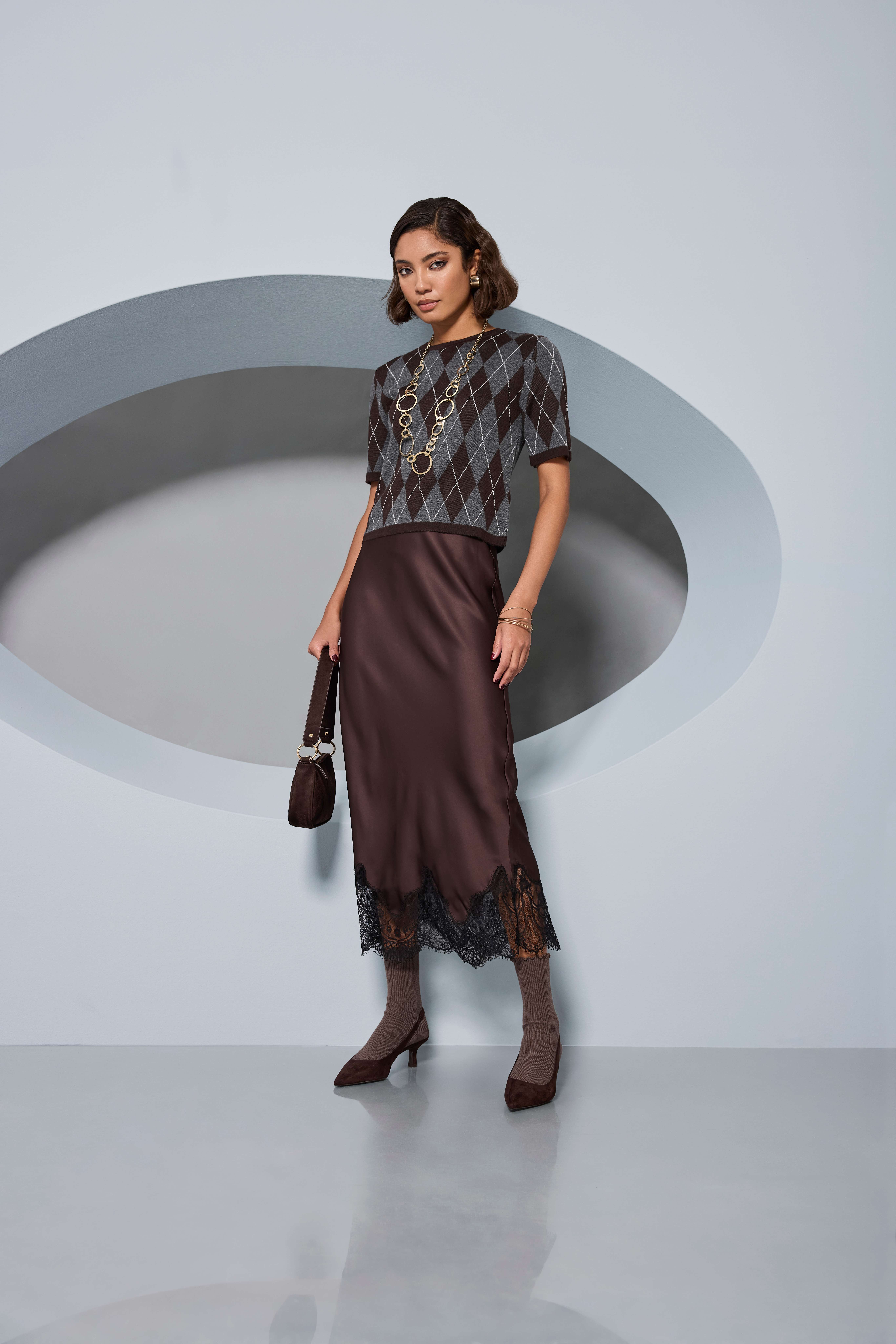 Frau in braun-grauem Oberteil, braunem Rock und braunen High Heels