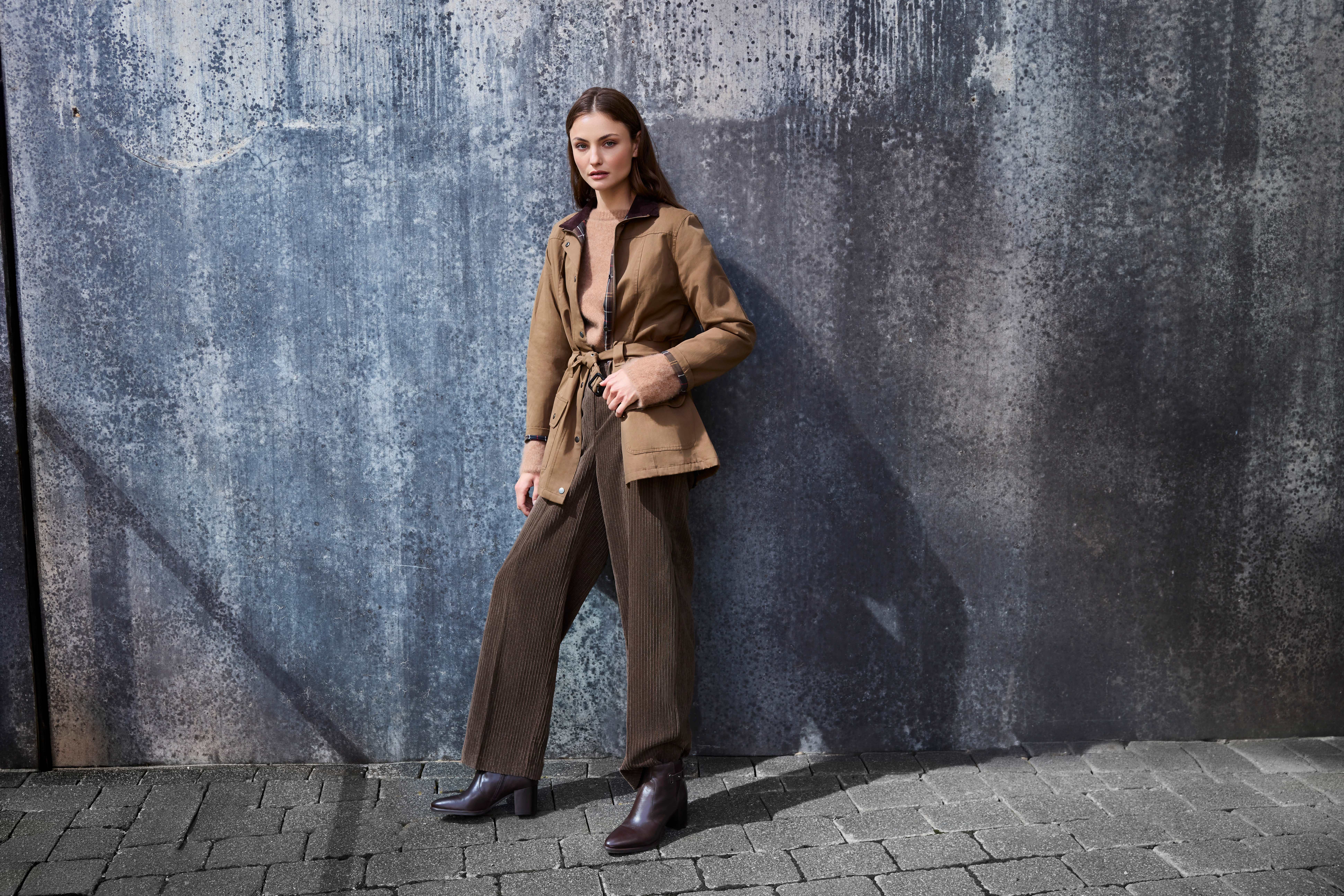 Frau in beiger Fieldjacket und brauner Cordhose kombiniert dunkelbraune Ankle Boots mit Blockabsatz