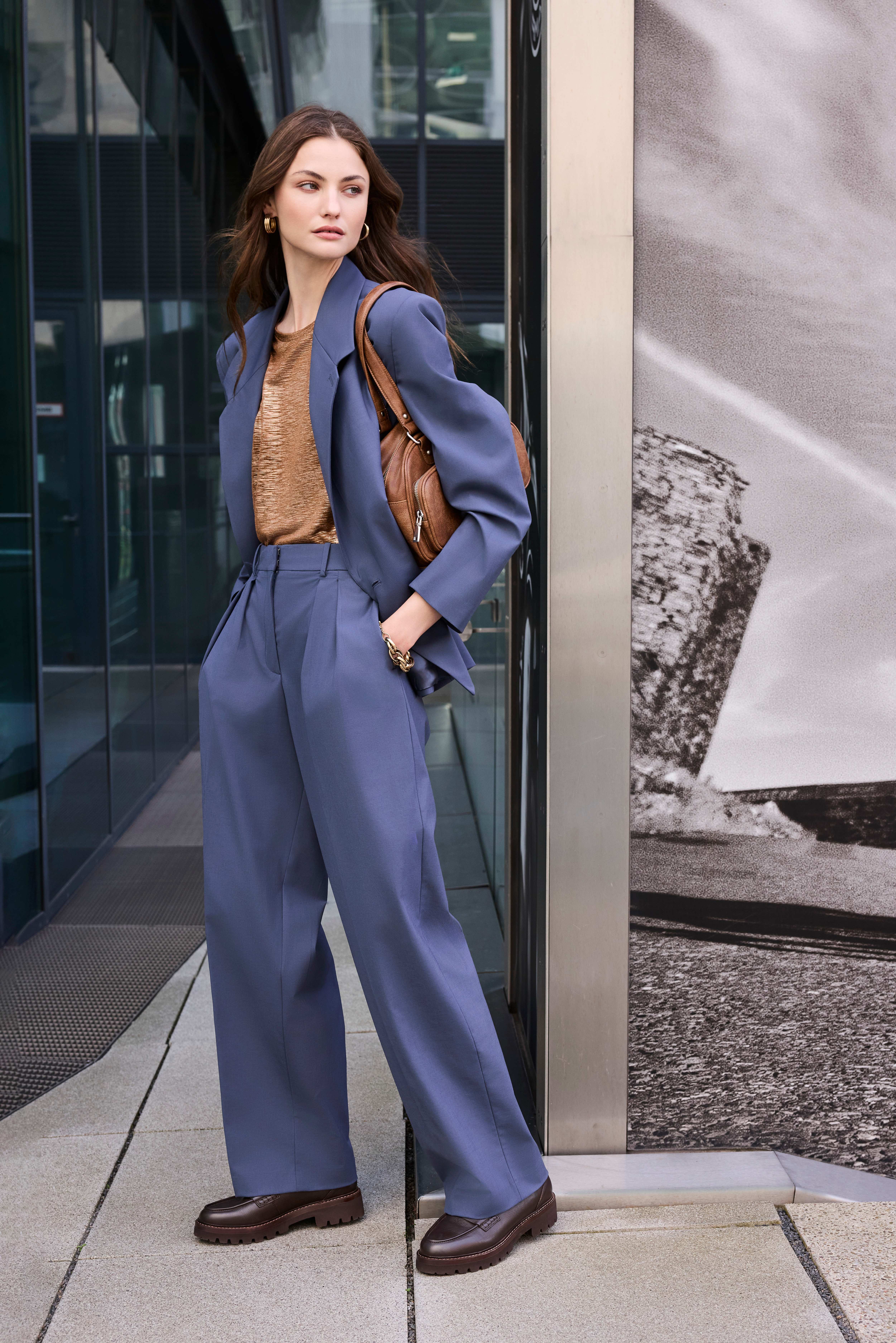 Frau im modernen Office-Look mit elegantem Hosenanzug und stilvollen Lederschuhen