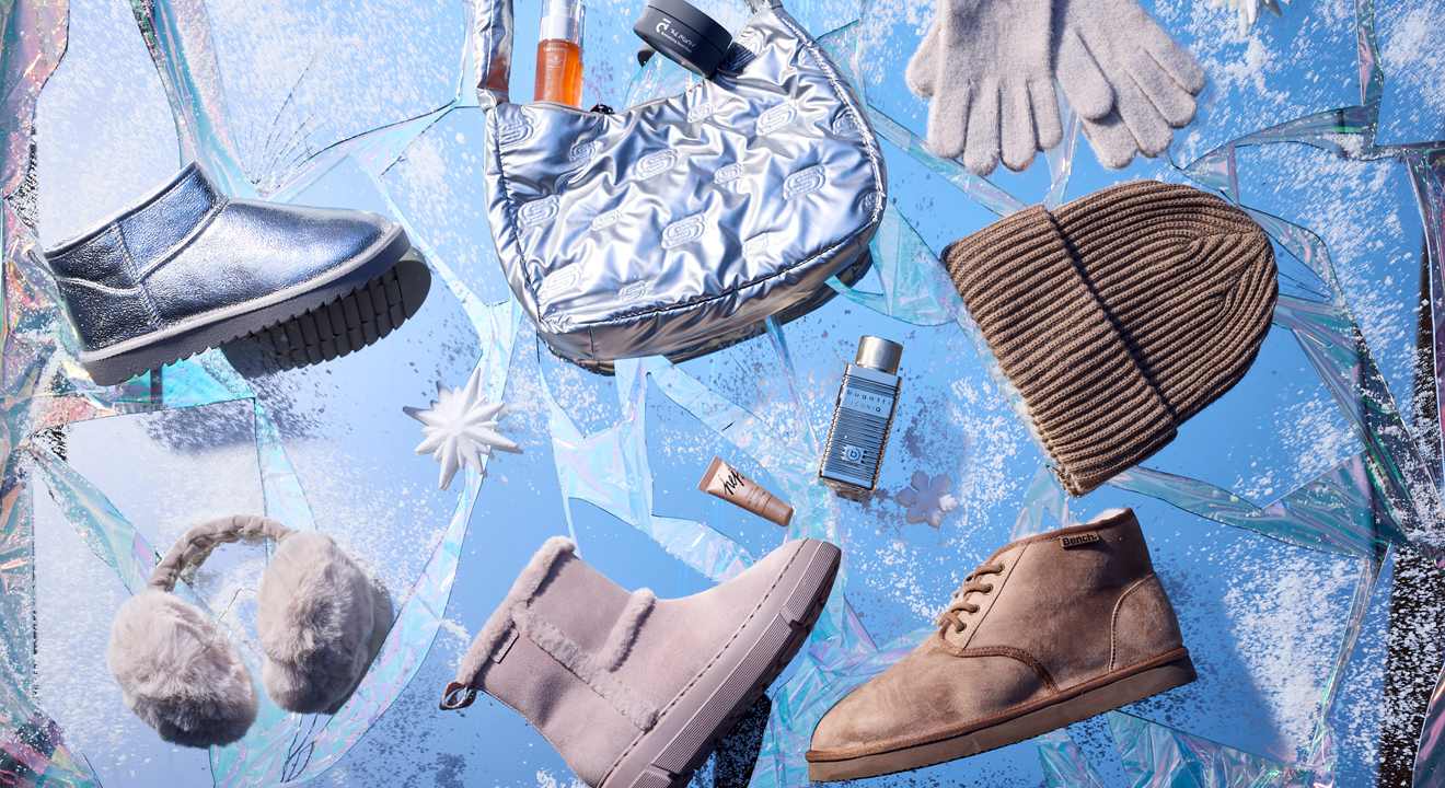 Kollektion einzelner Kleidungsstücke & Accessoires für Winter-Outfits auf blauer Oberfläche