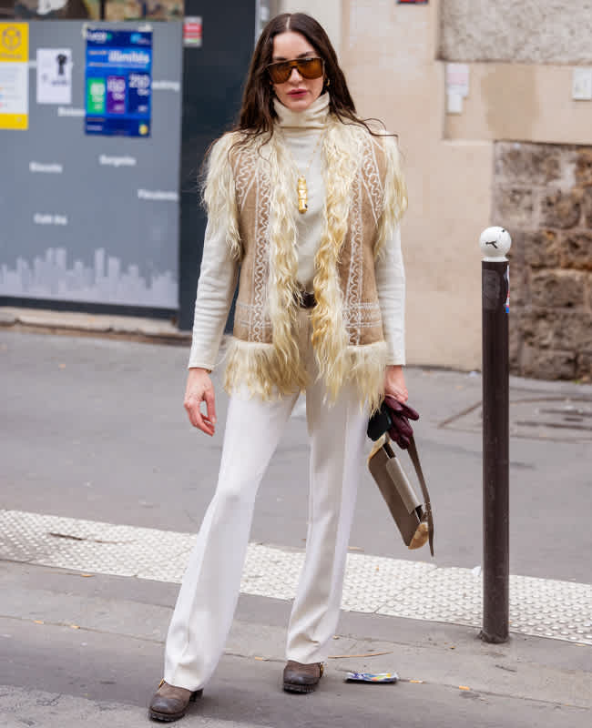 Frau mit Fake Fur-Weste und weißer Hose