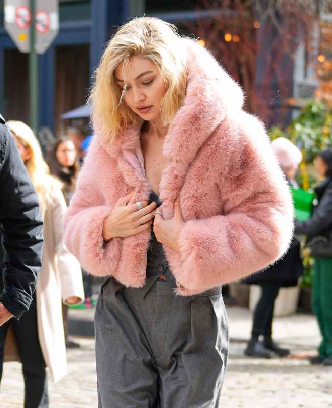 Blonde Frau mit Fake Fur-Bomberjacke und High-Waist-Jeans