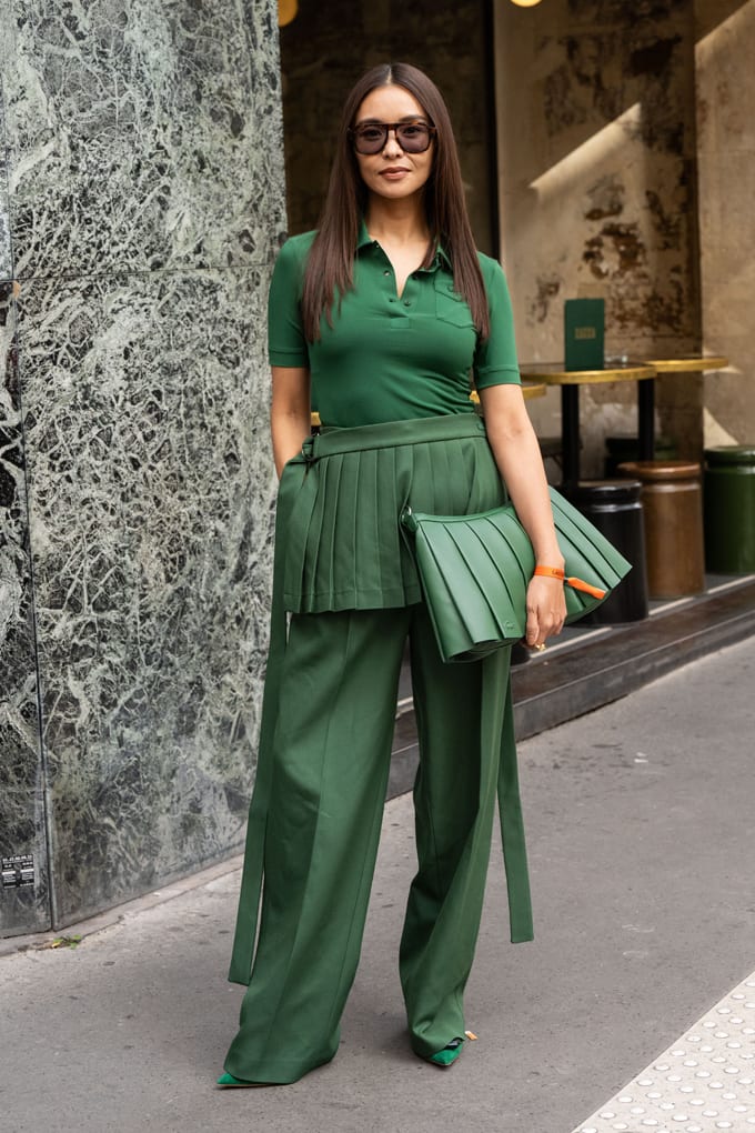 Frau mit Sonnenbrille in lässig-grünem Outfit mit grüner Fransen-Handtasche