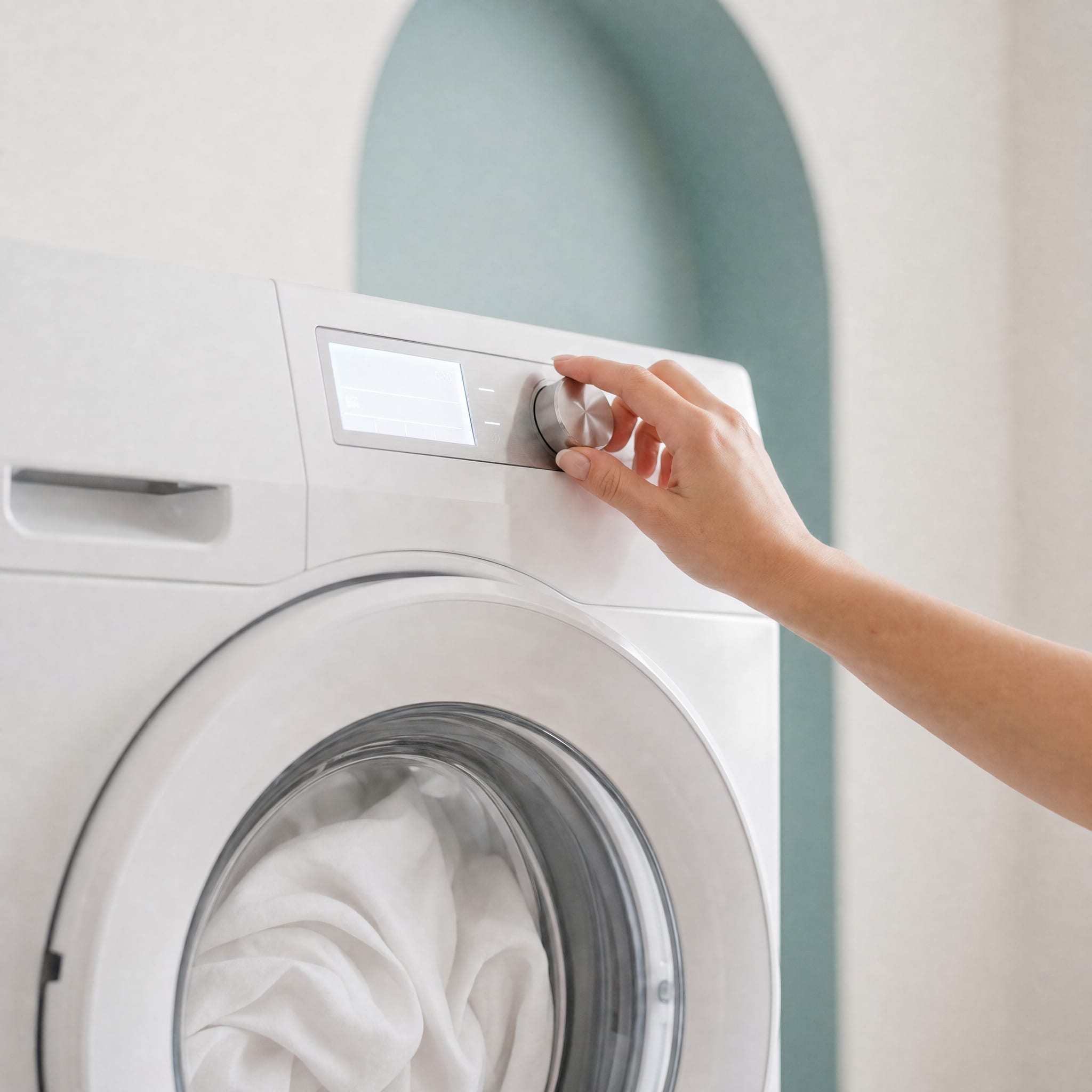 Frau bedient Waschmaschine voll mit weißer Kleidung
