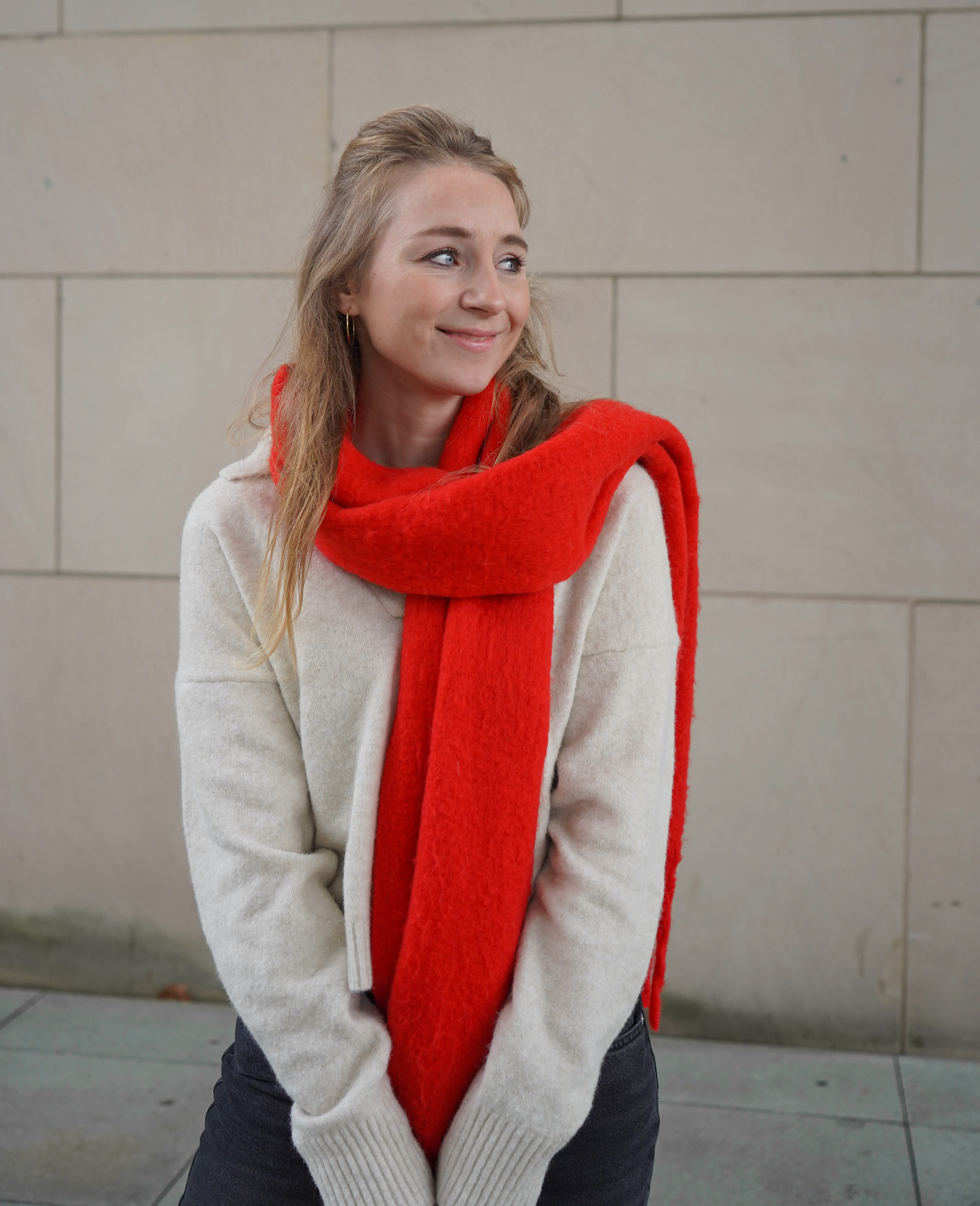 Frau in weißem Strickpullover, mit warmem, flauschigen Schal in Rot, gemütlicher Look