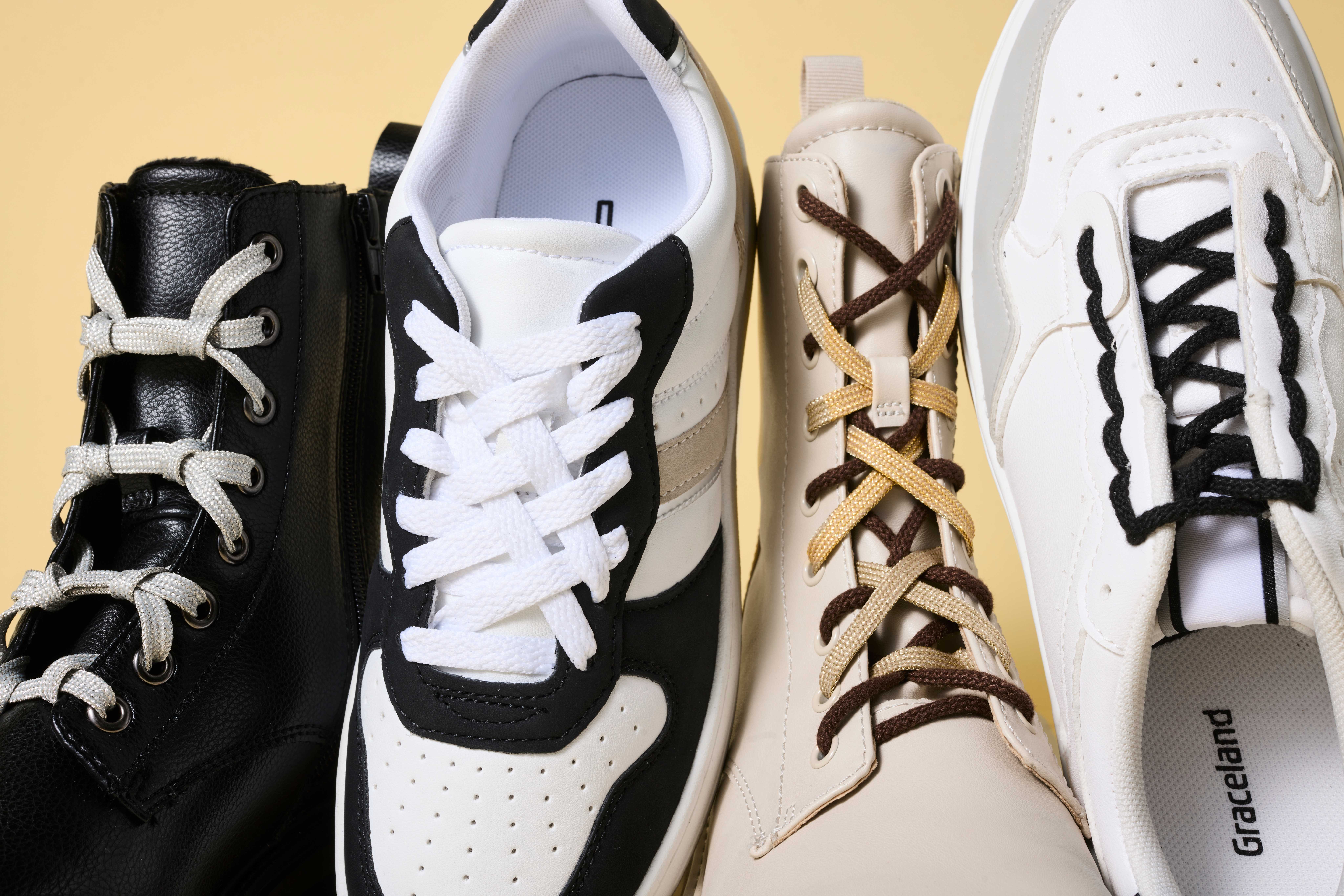 Vier Schuhe stehen nebeneinander, alle mit unterschiedlichen Schnürsenkel-Schnürungen