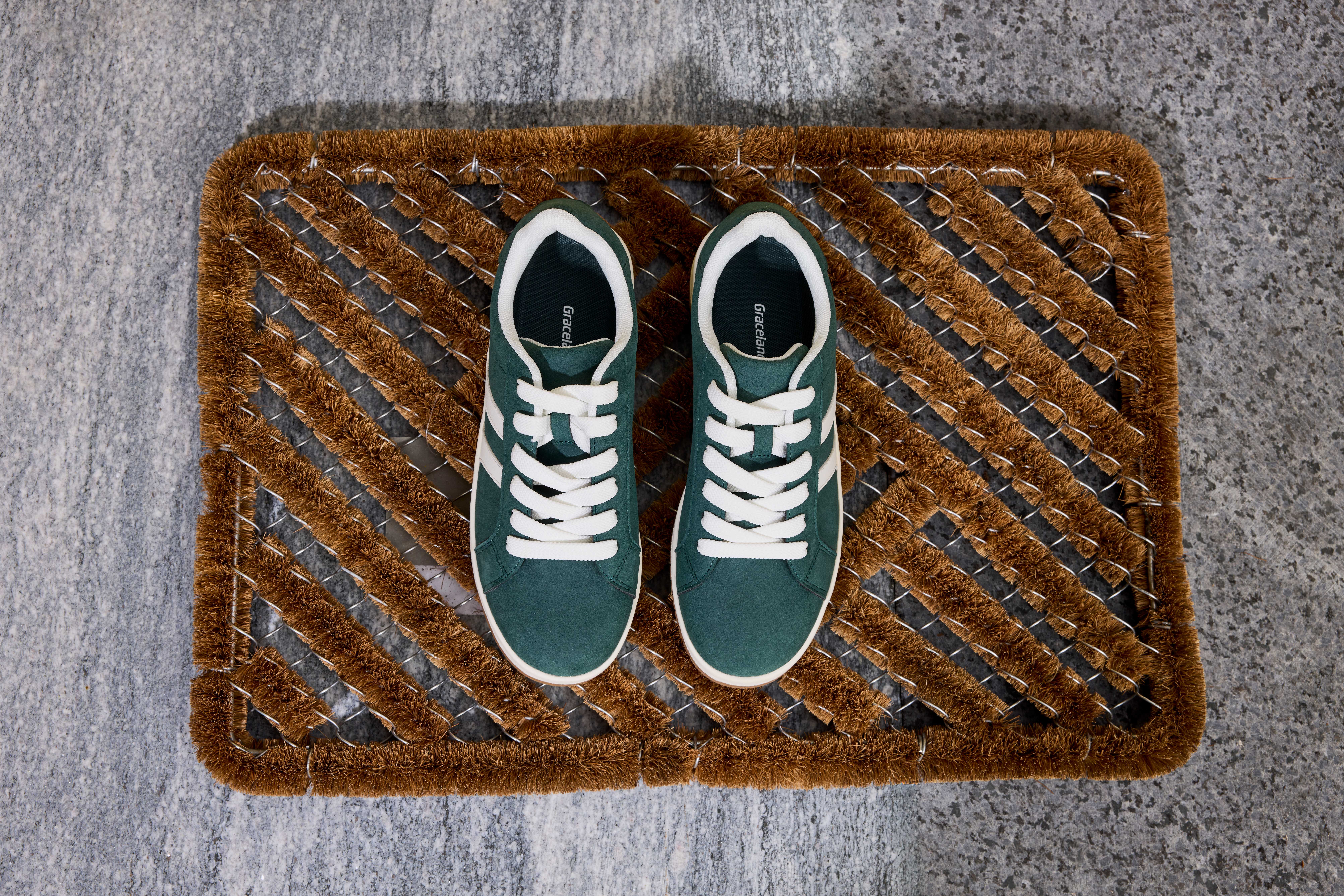 Zwei stinkende Schuhe stehen auf brauner Fußmatte zum Lüften