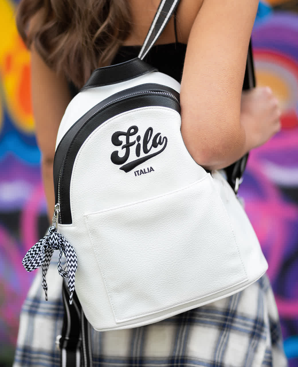 Frau trägt weißen Rucksack mit FILA-Schriftzug auf dem Rücken