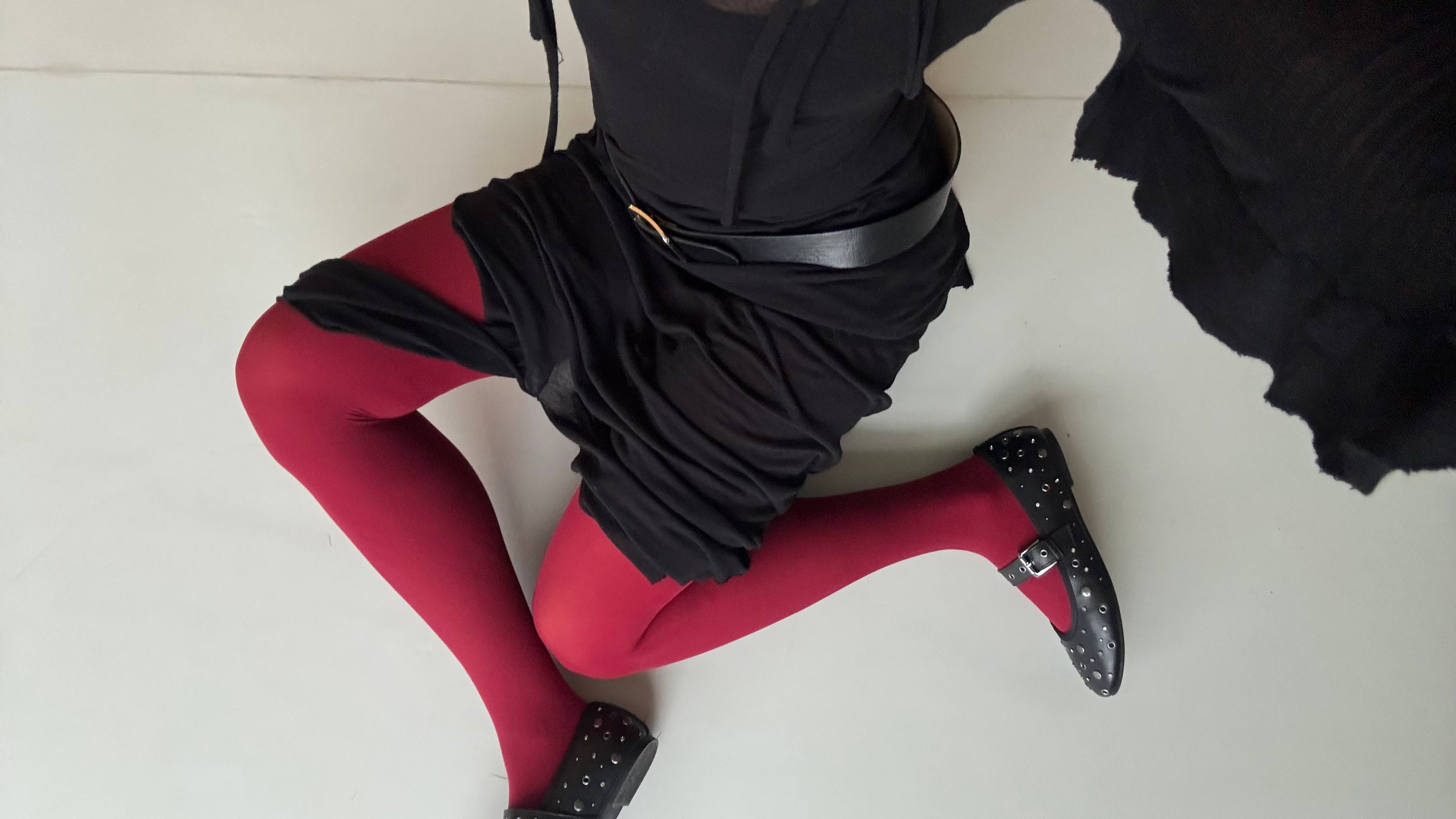 Close-Up einer Frau mit schwarzem Outfit und roter Strumpfhose