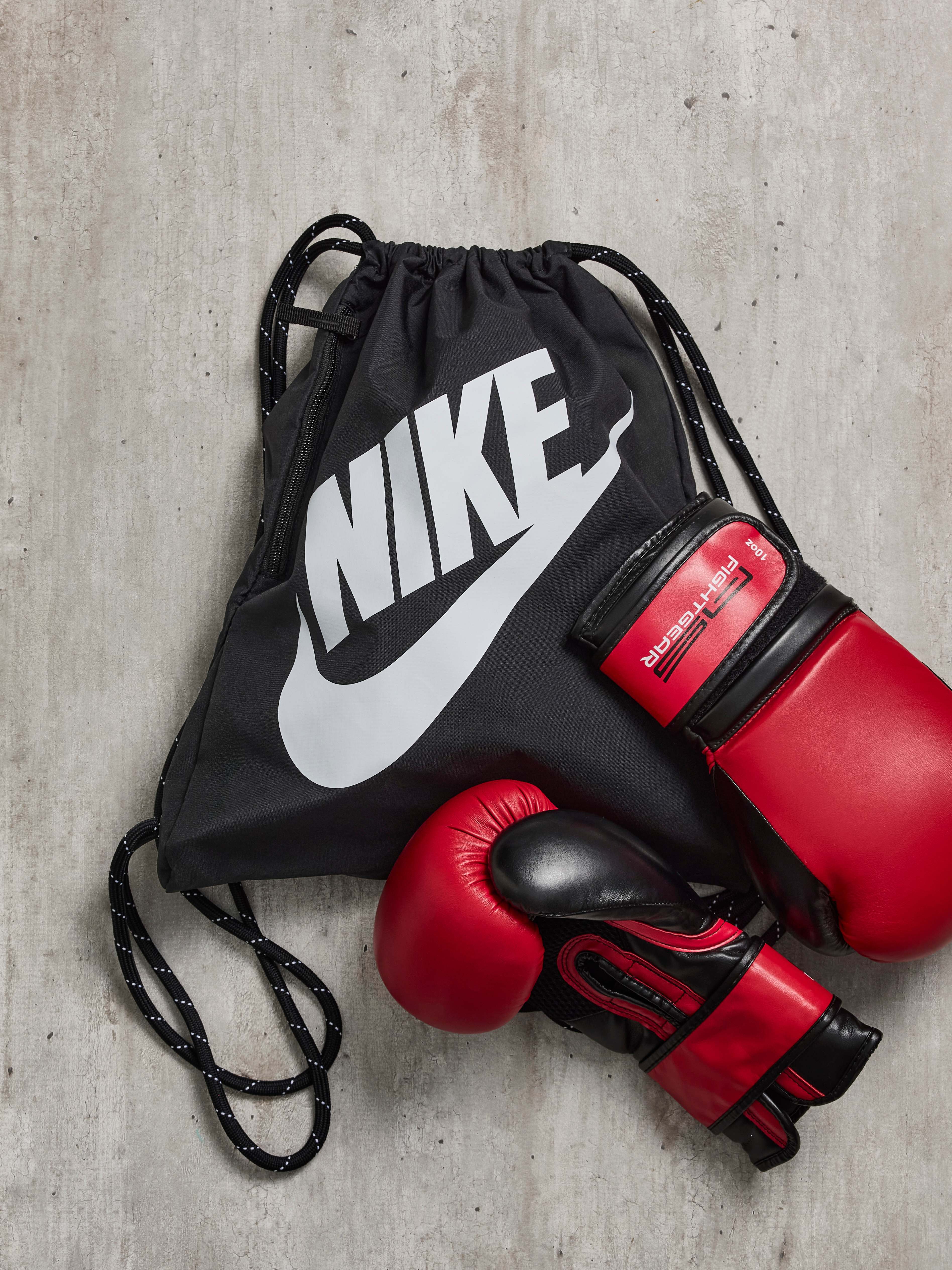 Schwarzer Nike-Rucksack, auf dem ein Paar Boxhandschuhe liegt
