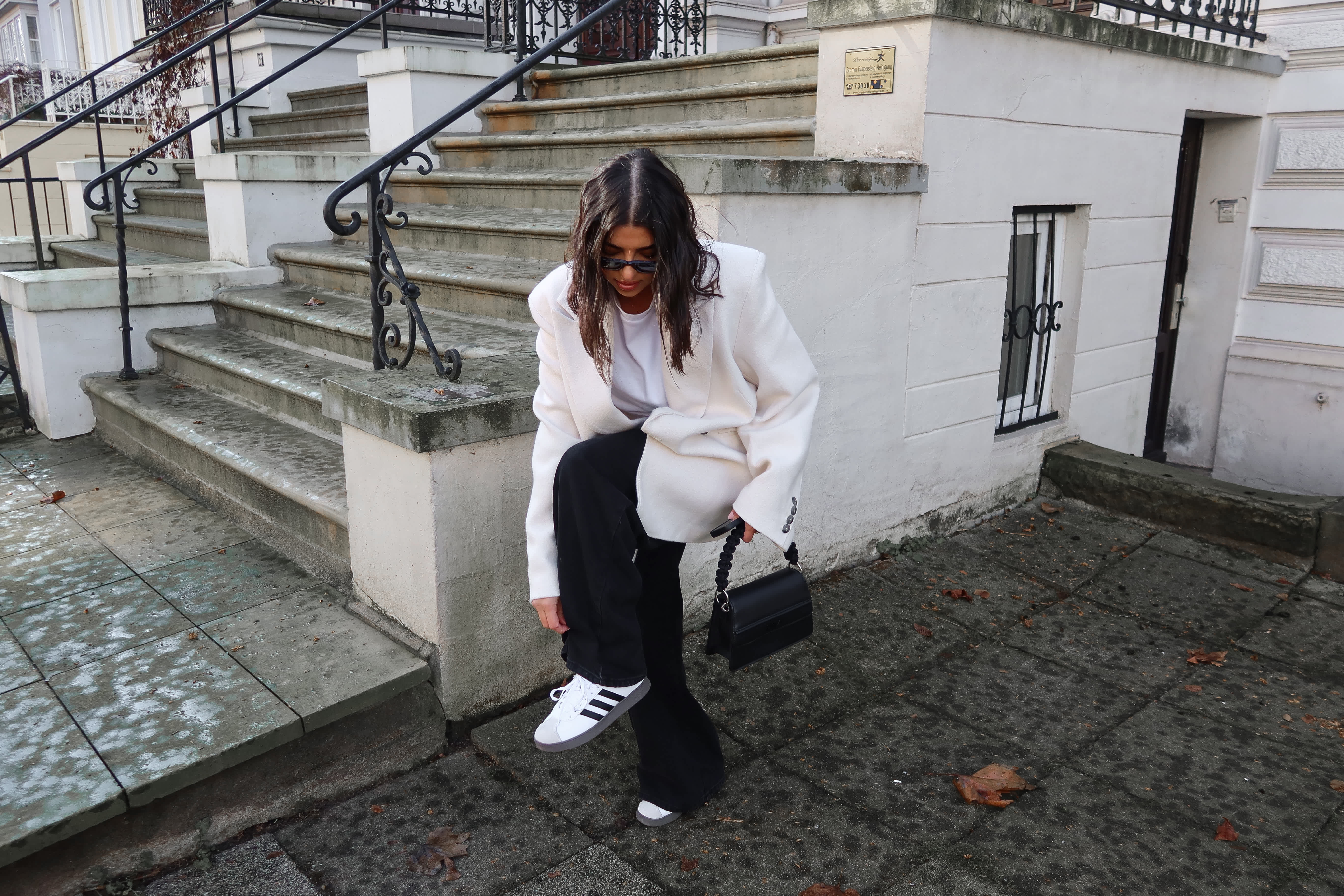 Frau steht auf einem Bein und justiert ihr anderes Hosenbein