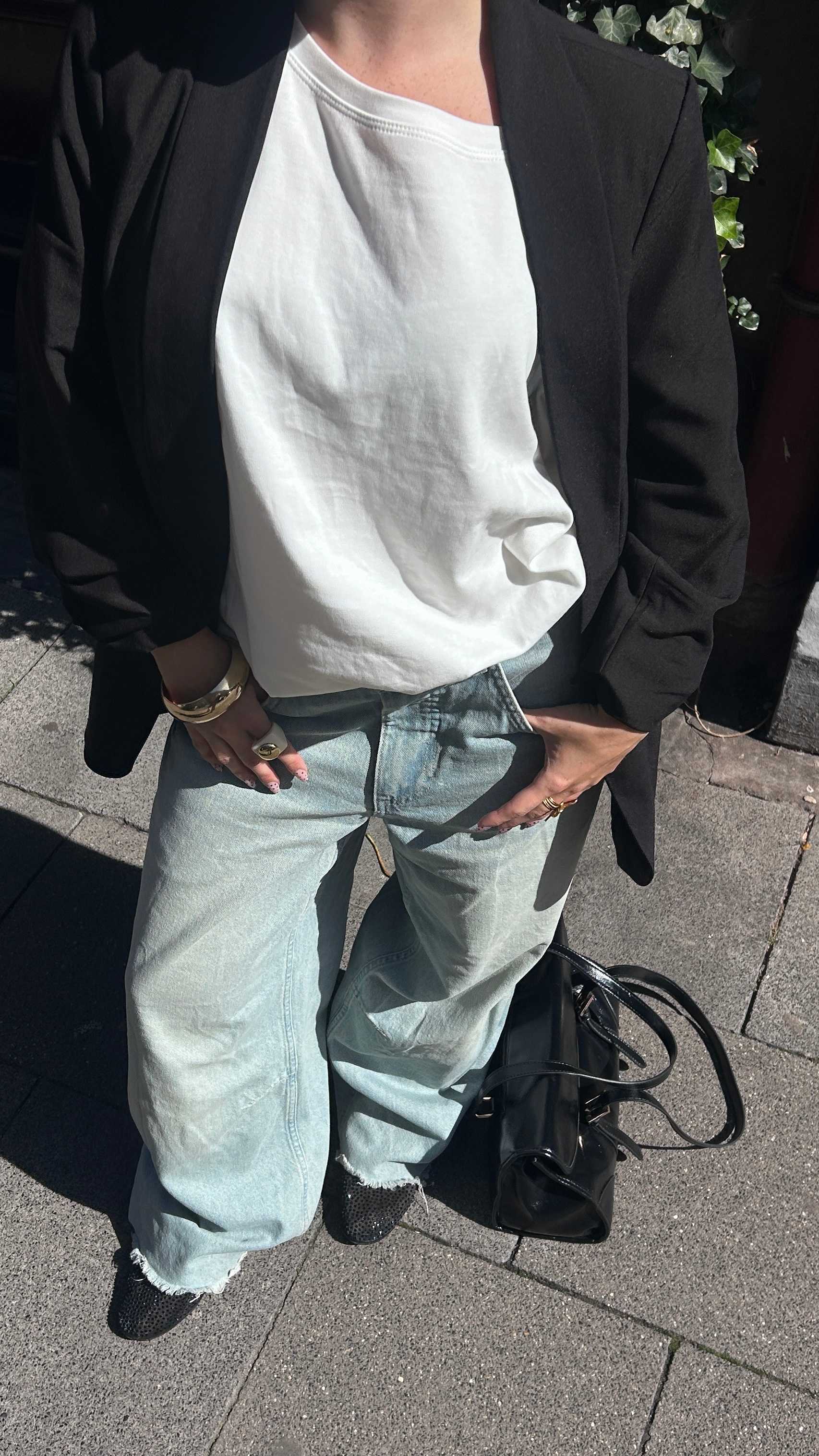 Close-Up einer Frau mit weißem Shirt, Blazer und Denim-Pants