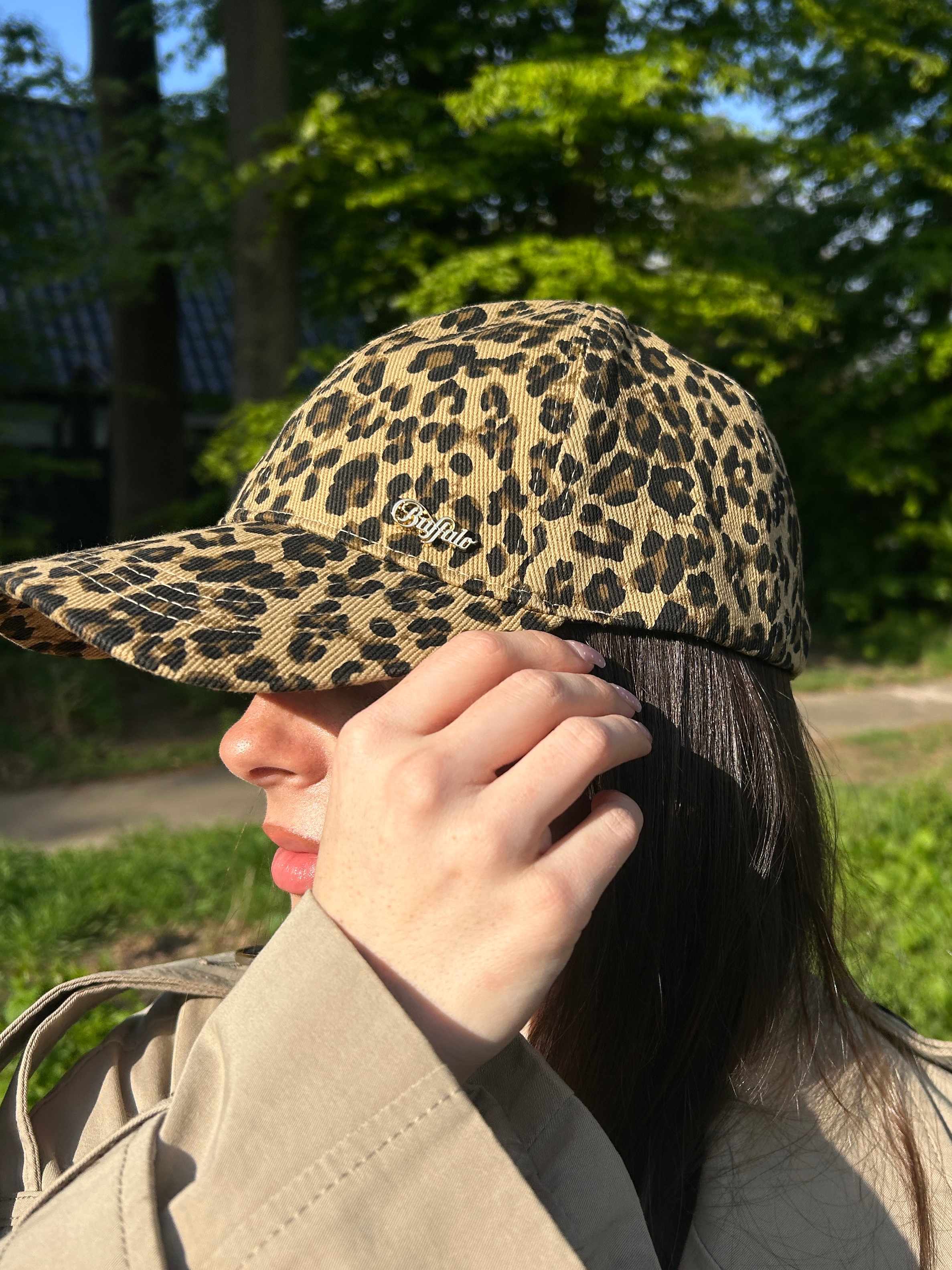 Junge Frau trägt Basecap mit Leoparden-Muster auf Kopf