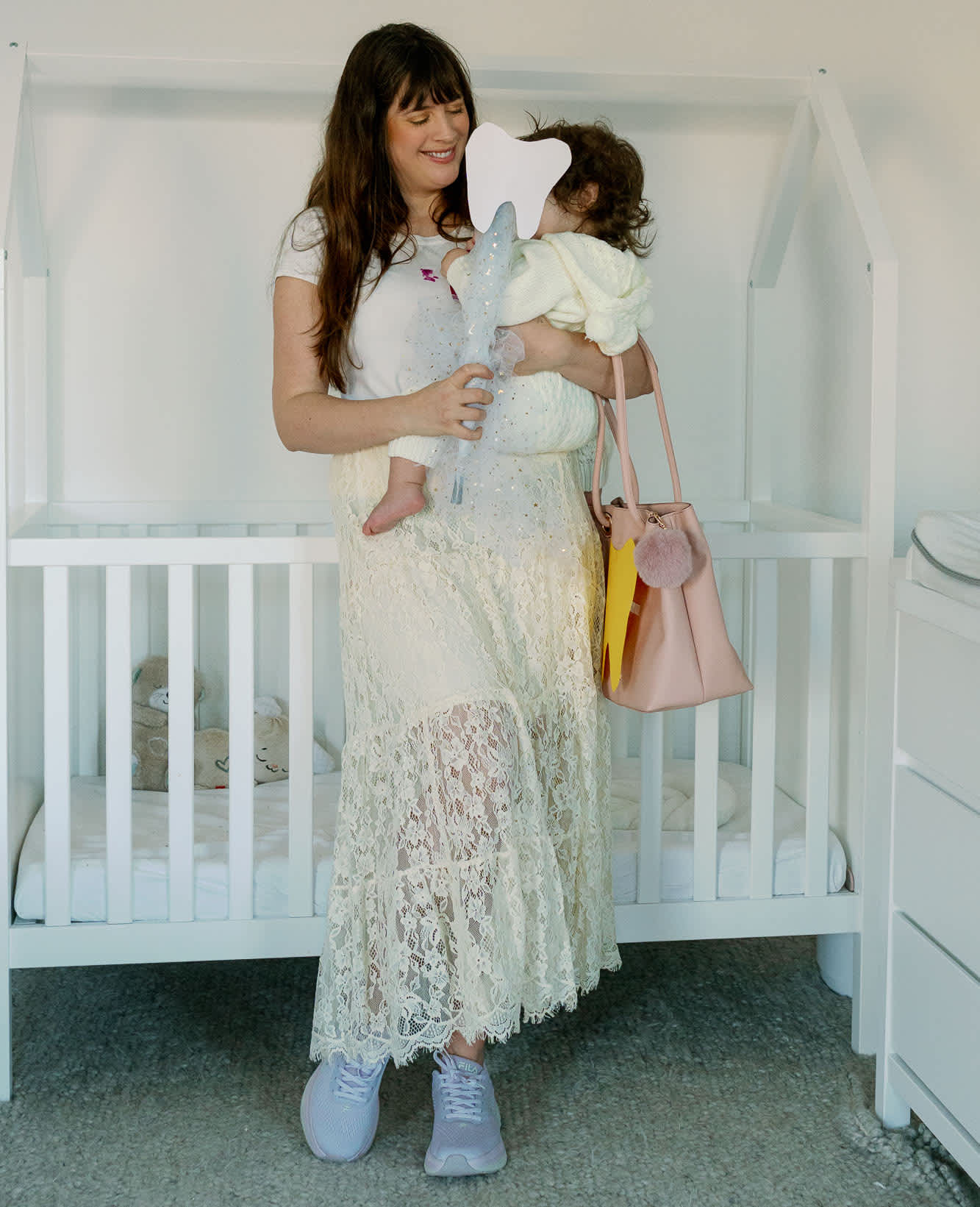 Frau in Zahnfee-Kostüm mit Baby auf dem Arm