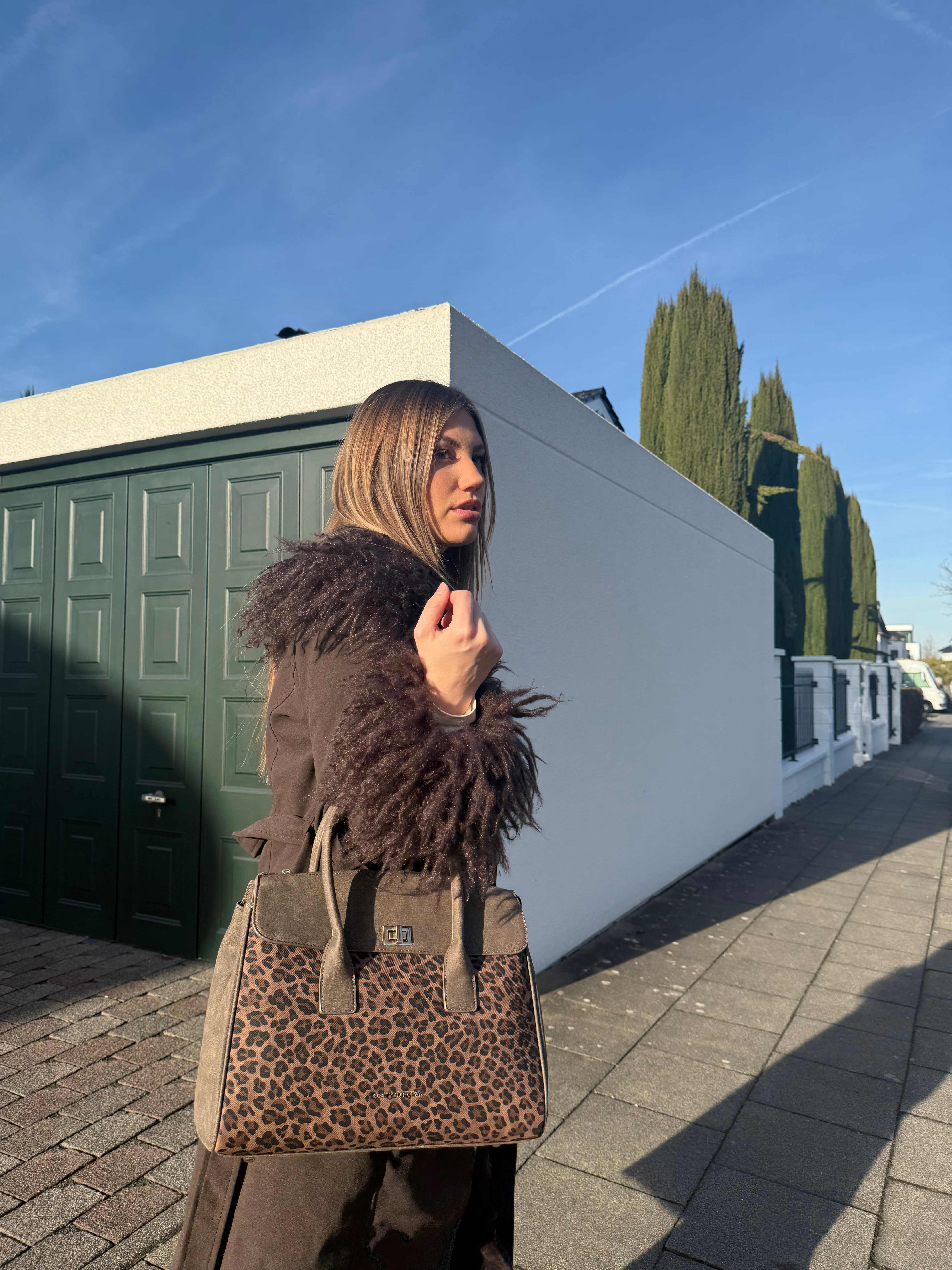 Blonde Frau posiert mit Handtasche im Animal Print-Look