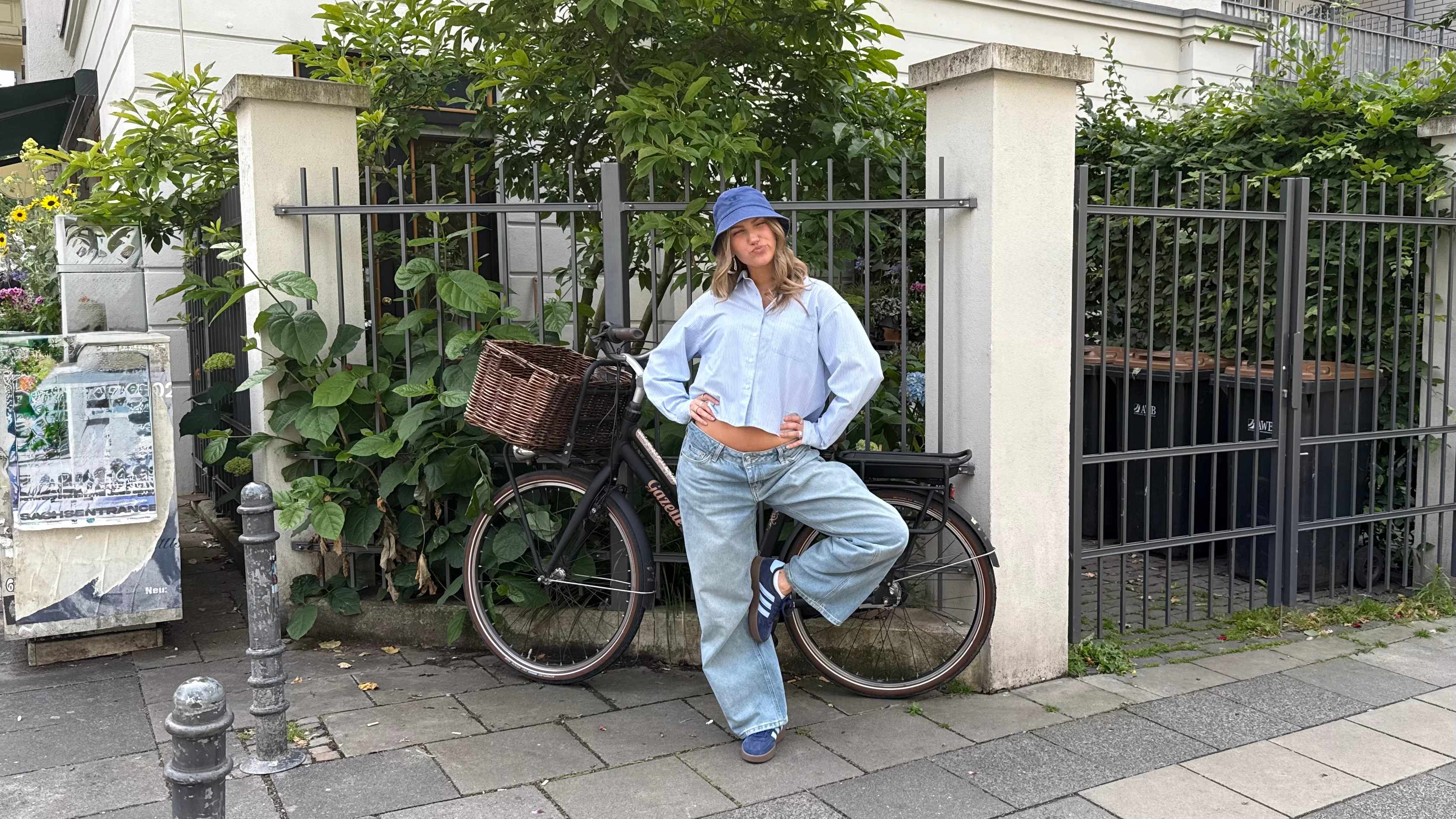 Frau präsentiert ihr cooles Outfit mit Bucket Hat in blauem Ton