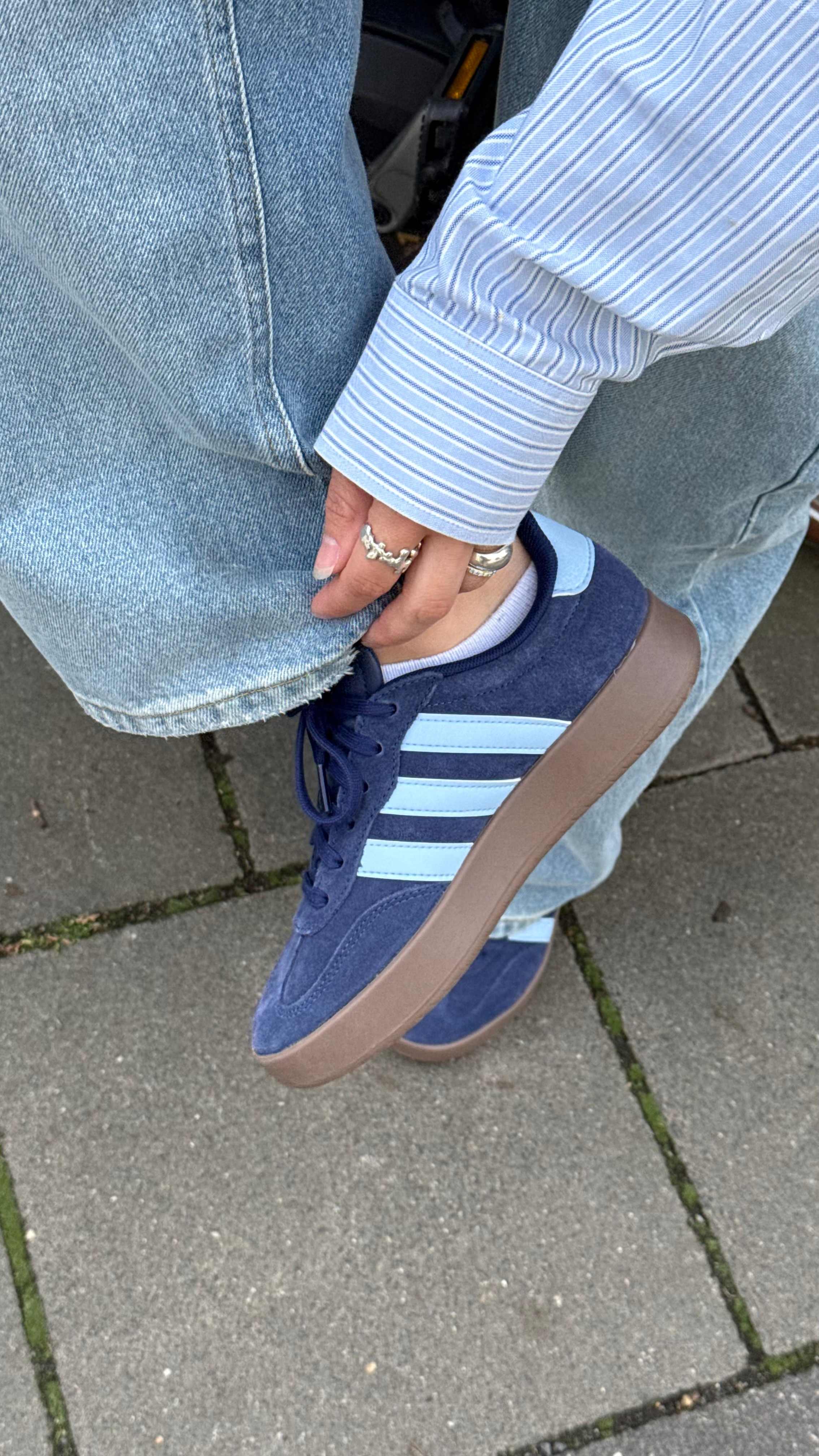 Frau präsentiert ihre Sneaker in blau von Adidas