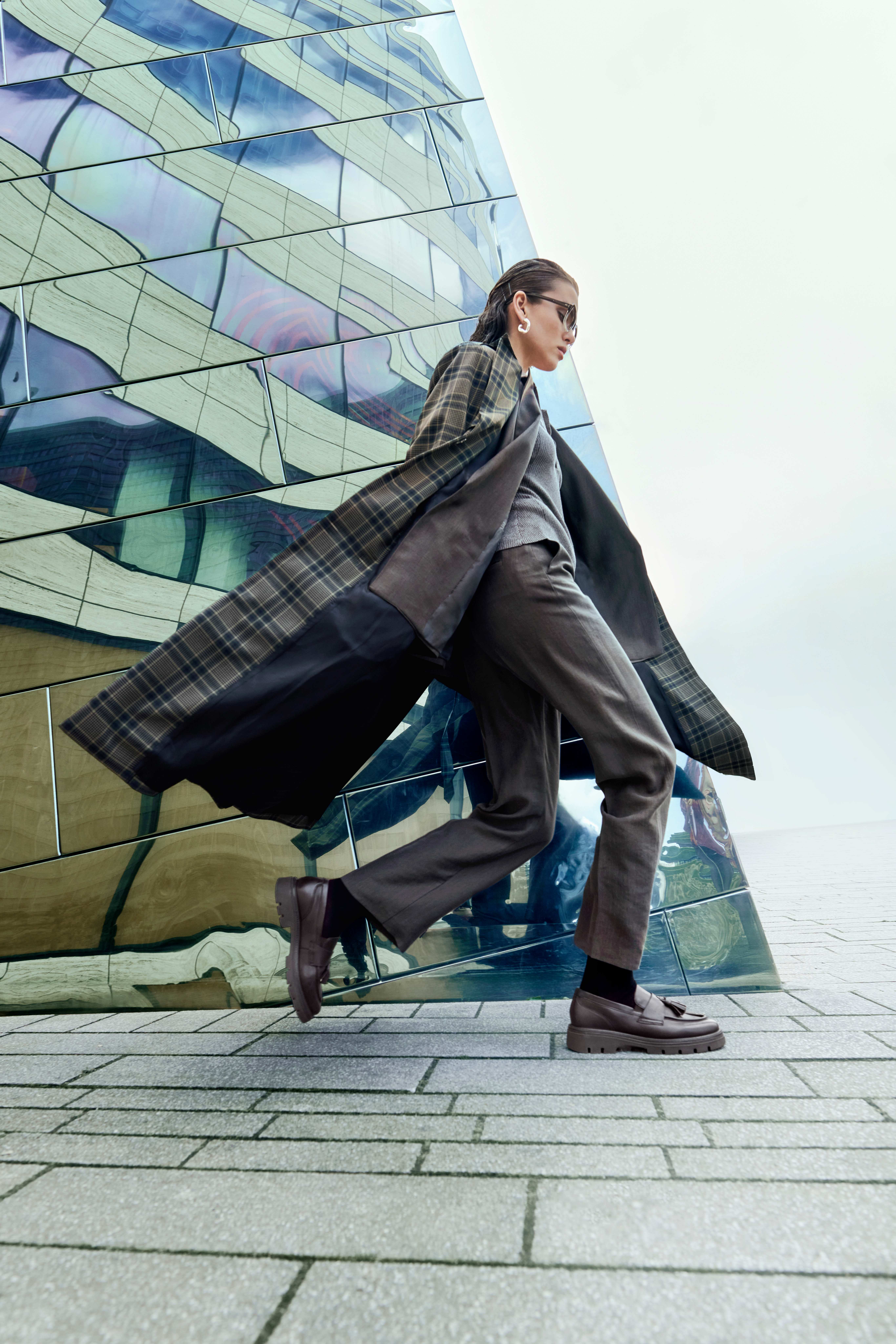 Modernes Streetstyle-Outfit mit langem kariertem Mantel, lässiger Silhouette und markanten Loafern