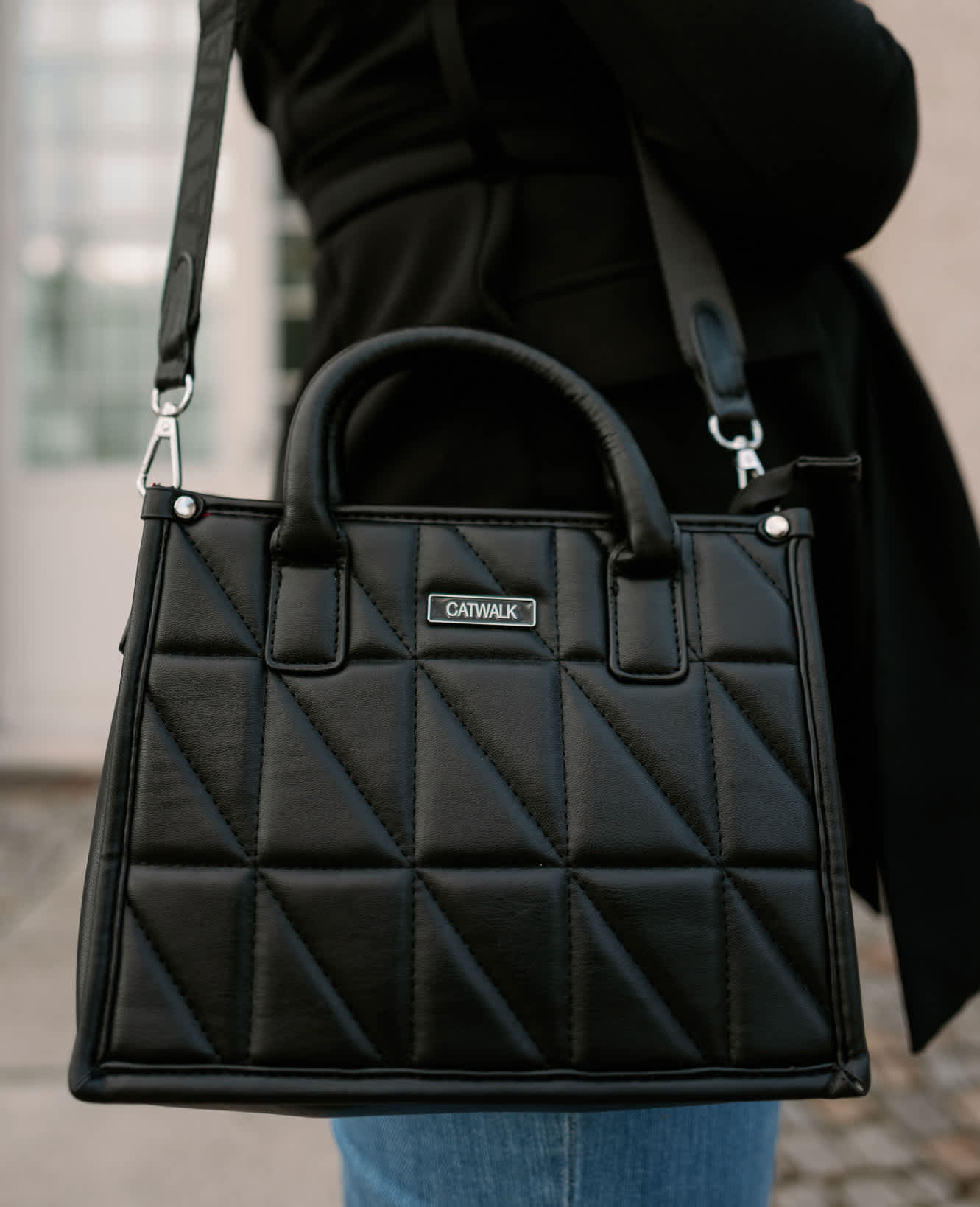 Fokus auf die schwarze Ledertasche von CATWALK passend zu den Schuhen
