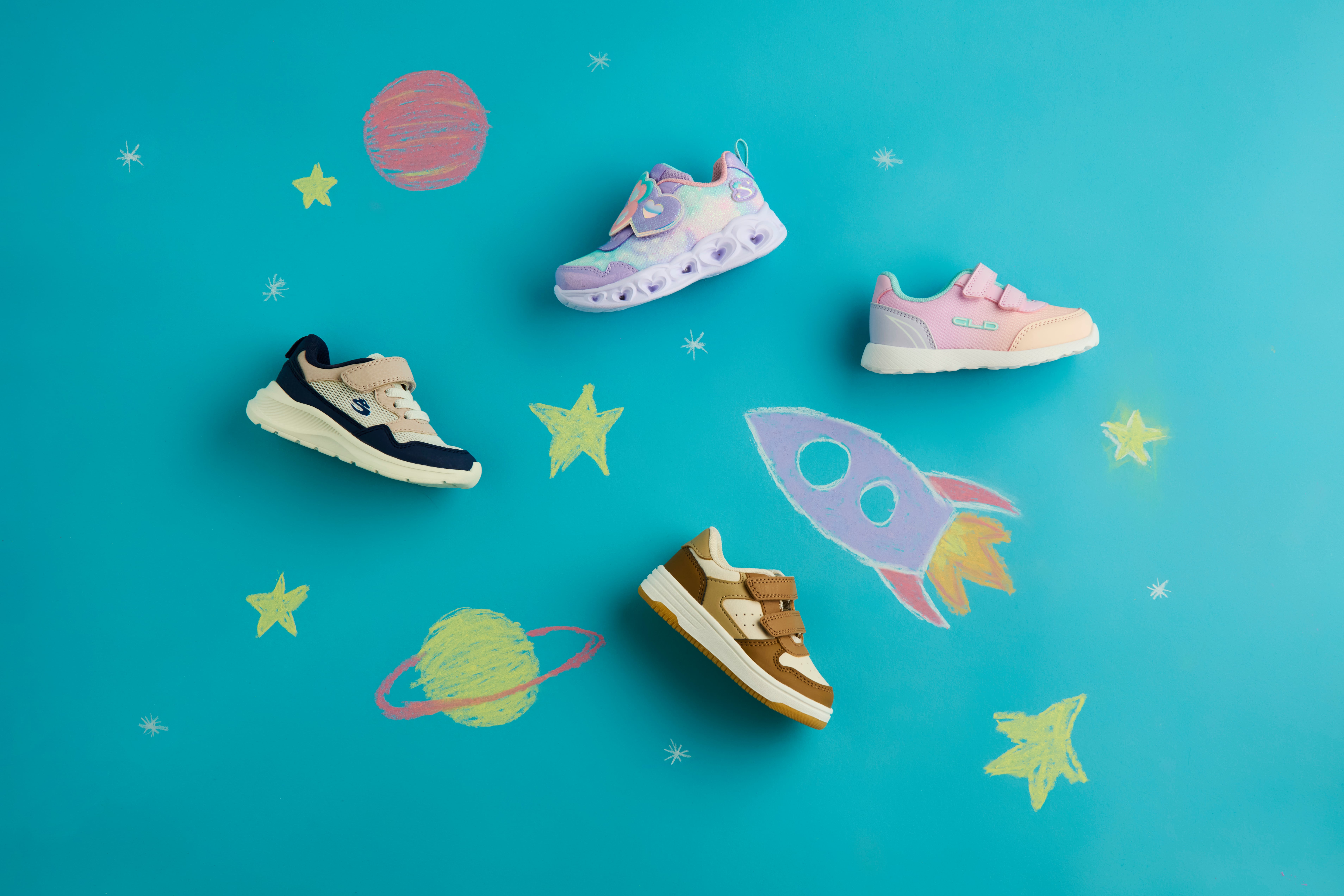 Vier Kinderschuhe auf türkisfarbenem Hintergrund