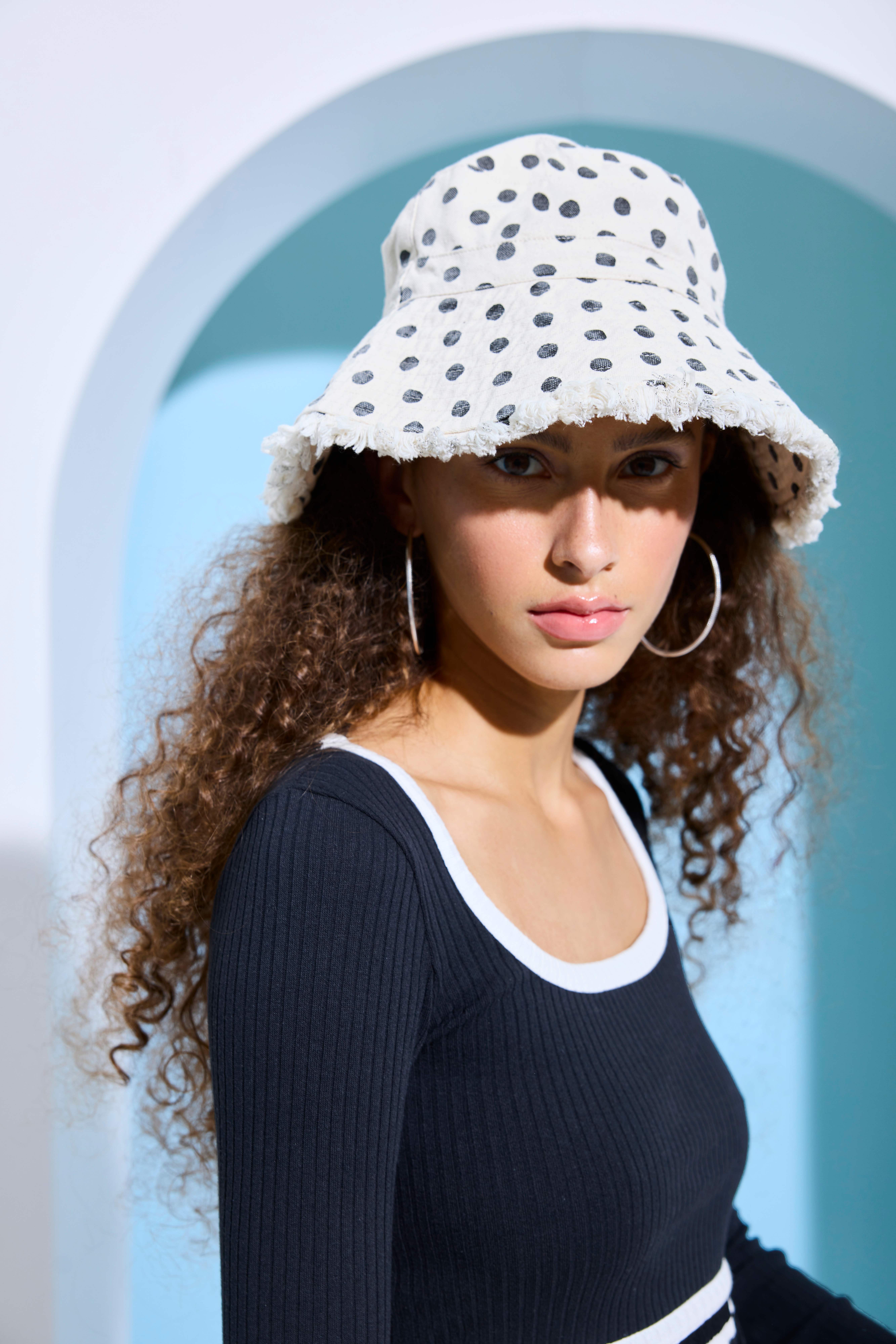 Frau mit lockigen Haaren trägt Bucket Hat im Dalmatiner-Design