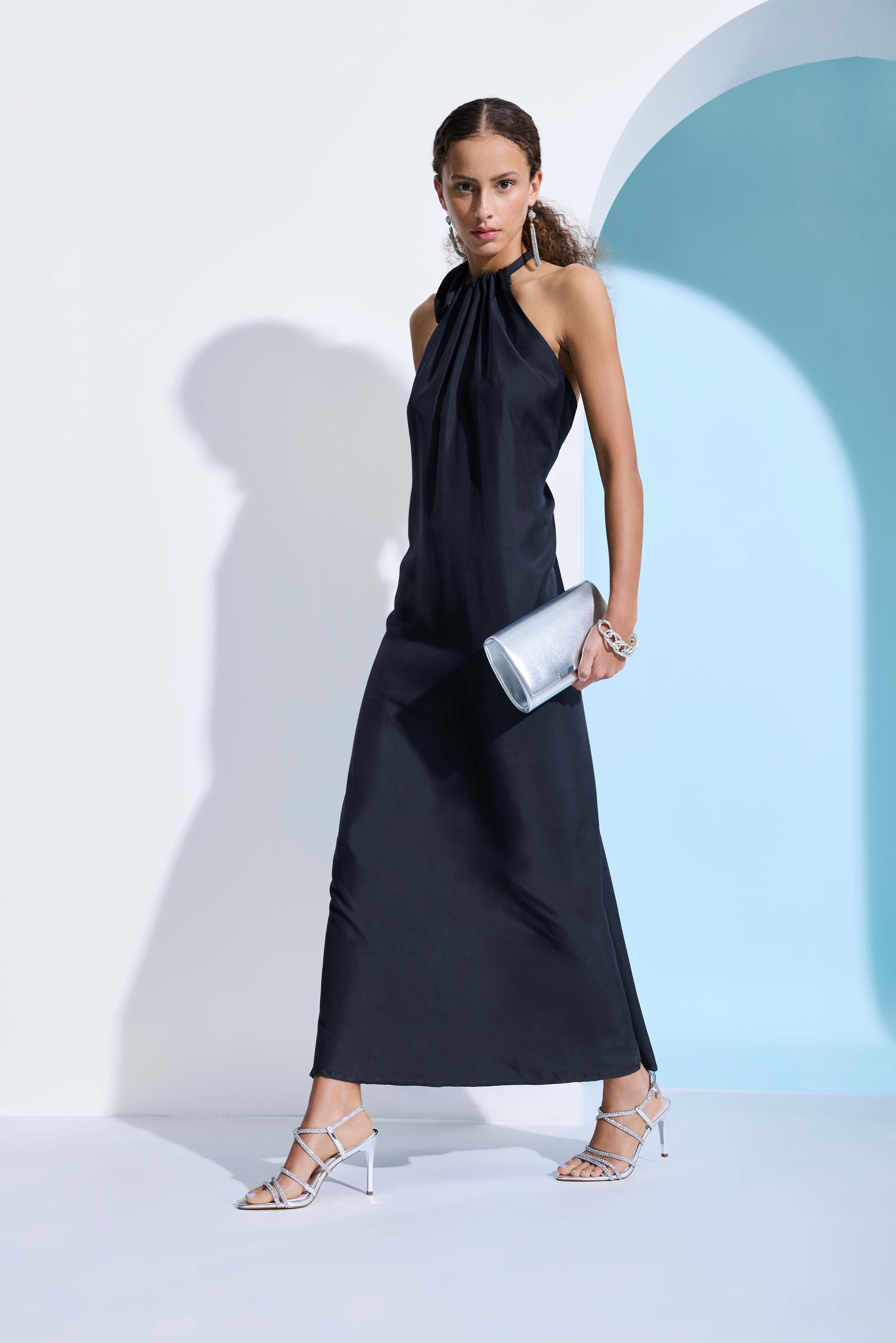 Person im eleganten Evening‑Dress, kombiniert mit filigranen Strappy‑Heel‑Sandaletten