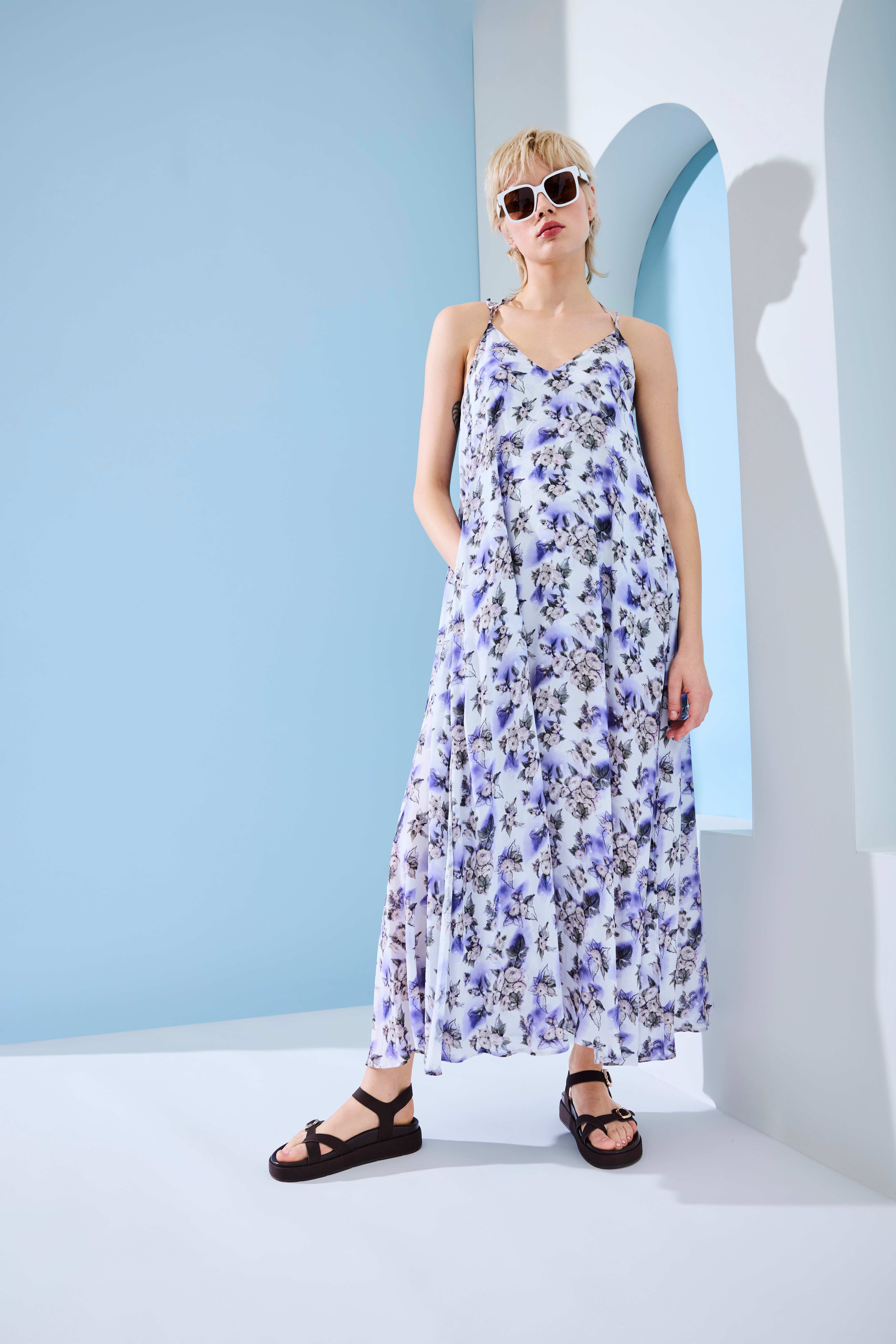 Person im floralen Maxi‑Kleid, kombiniert mit schwarzen Chunky Sandalen