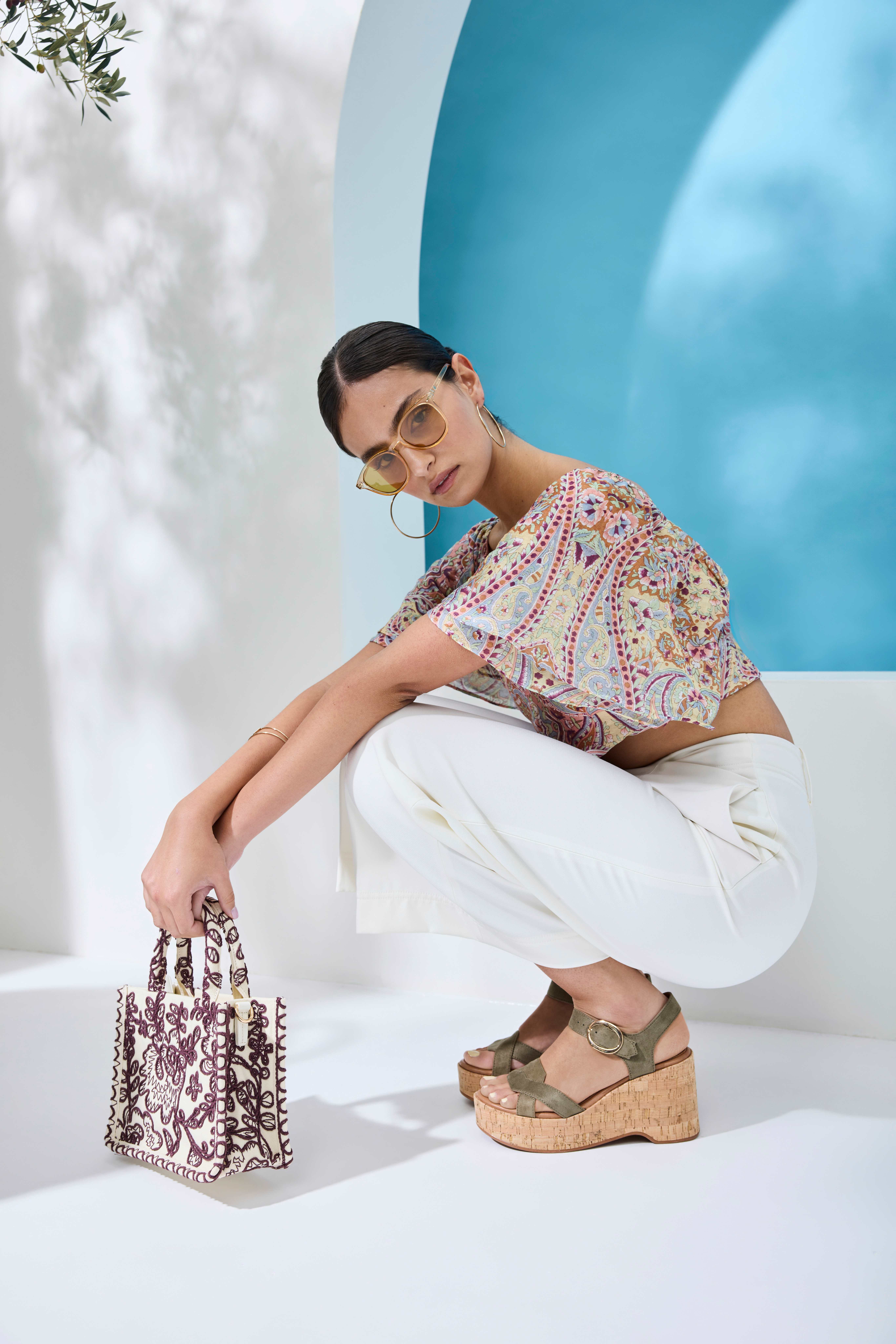 Person in gemusterter Print‑Bluse und heller Culotte, kombiniert mit Plateau‑Sandaletten mit Korksohle