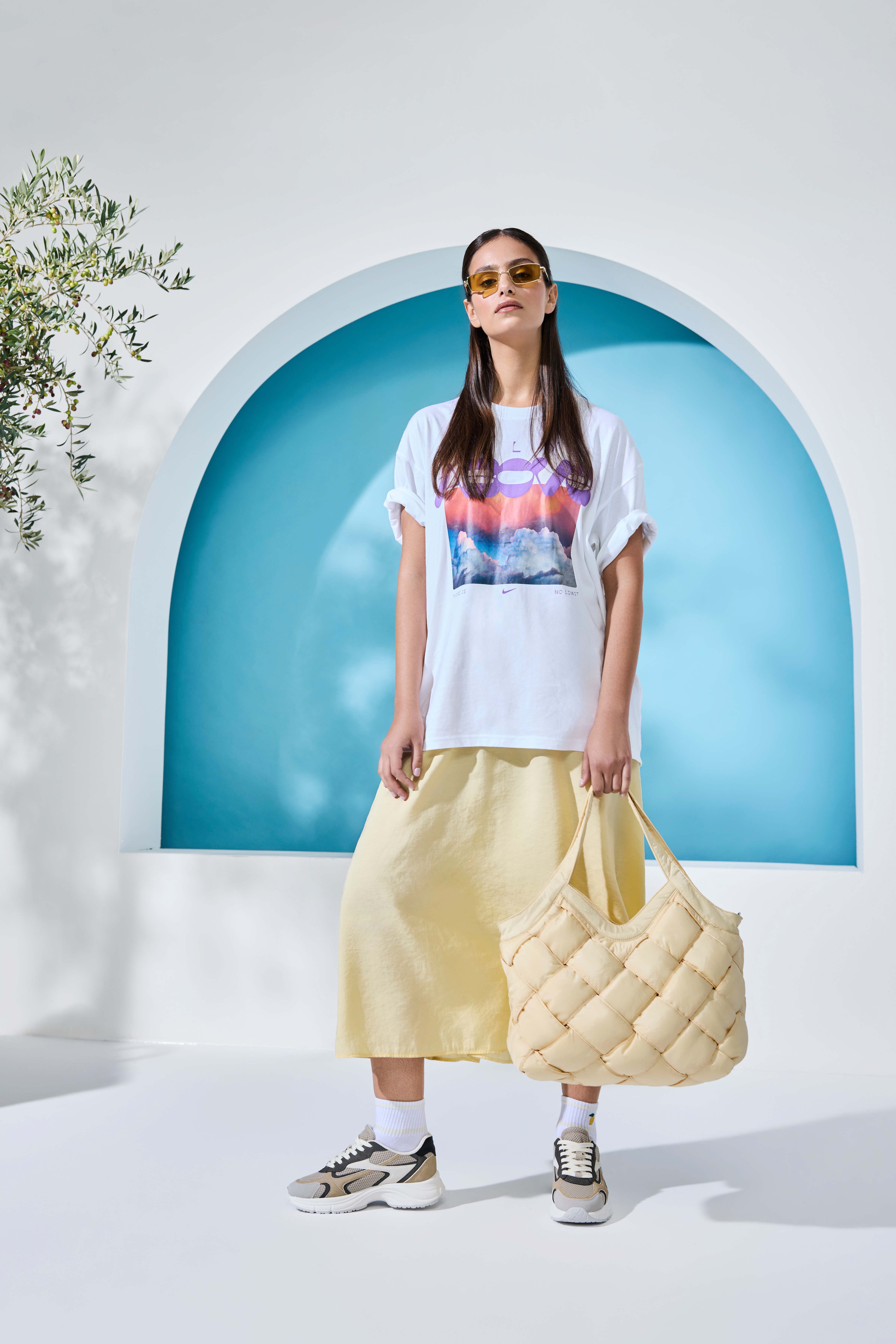 Frau in weißem Schlabber-Shirt mit gelbem Rock