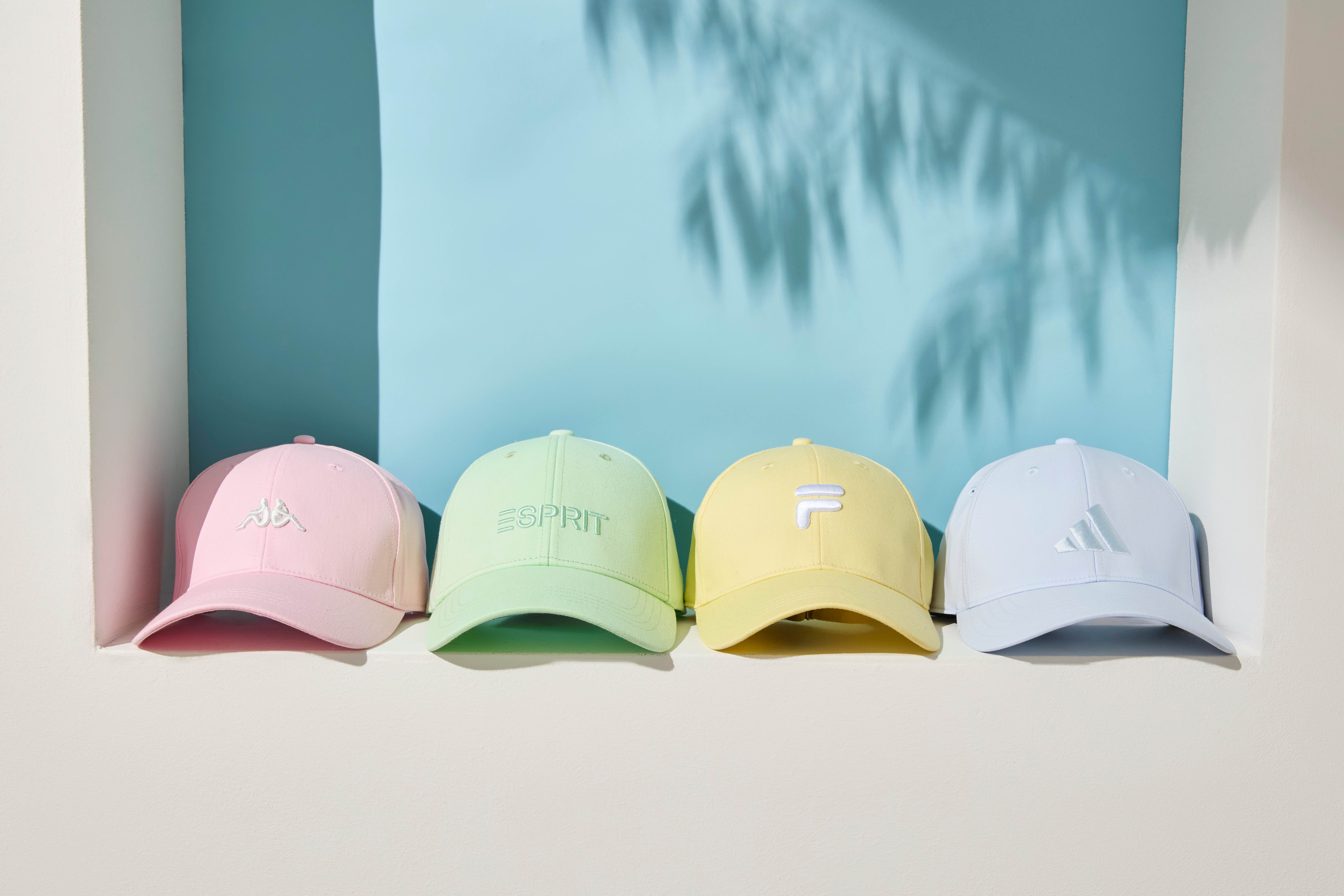 Vier Mützen in unterschiedlichen Farben liegen nebeneinander