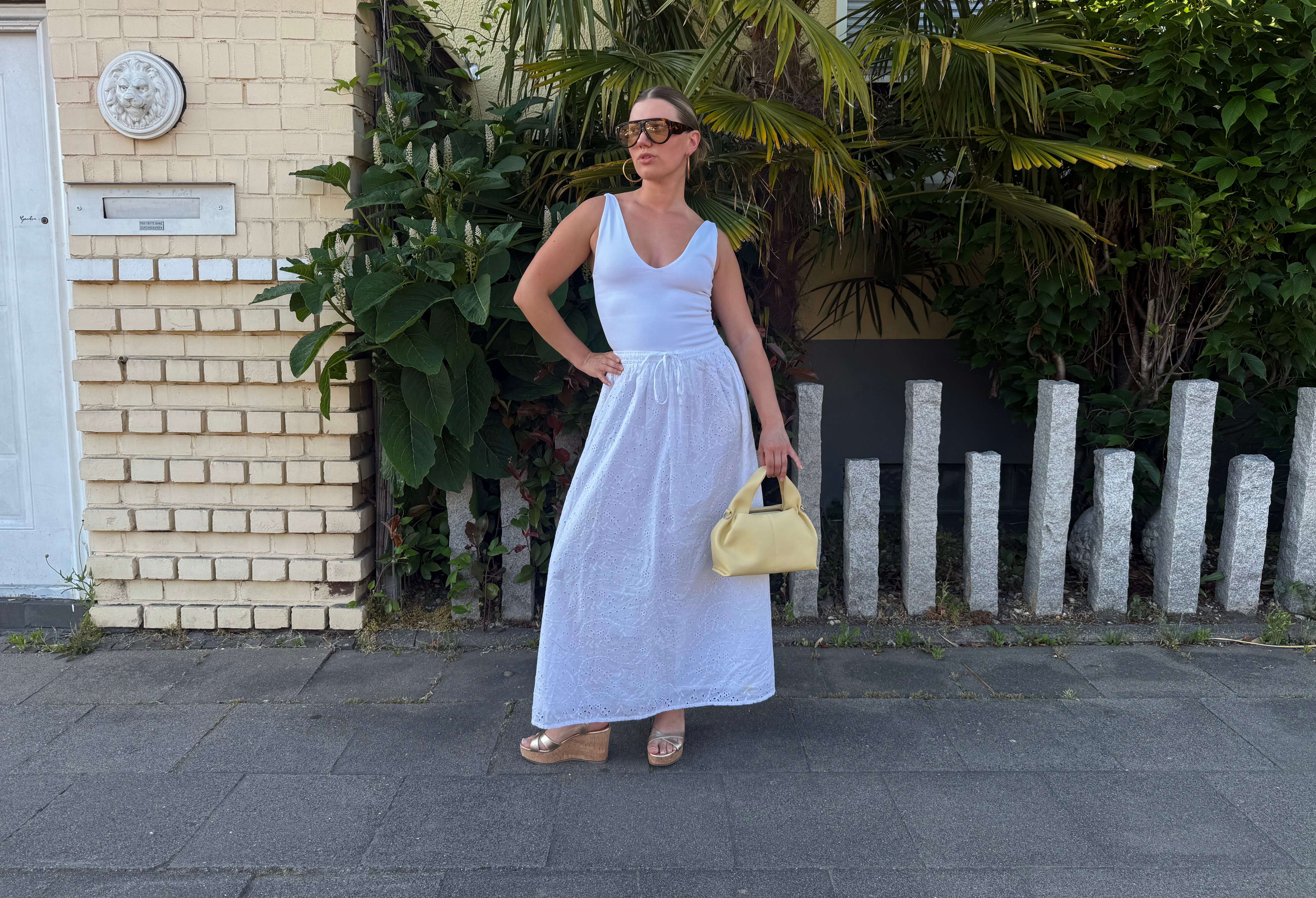 Frau in weißem Sommerkleid trägt Kork Wedges 