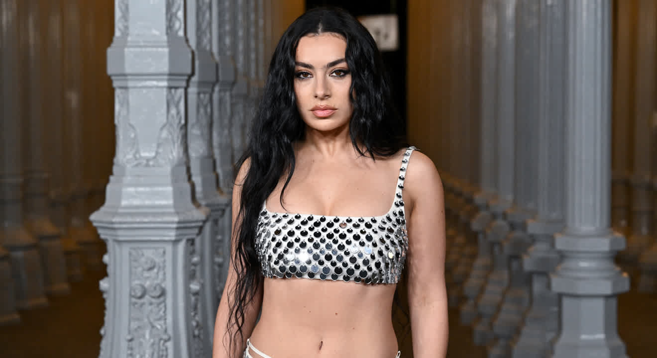 Sängerin Charli XCX bauchfrei mit weißem Top und Rock, beide mit Pailletten besetzt