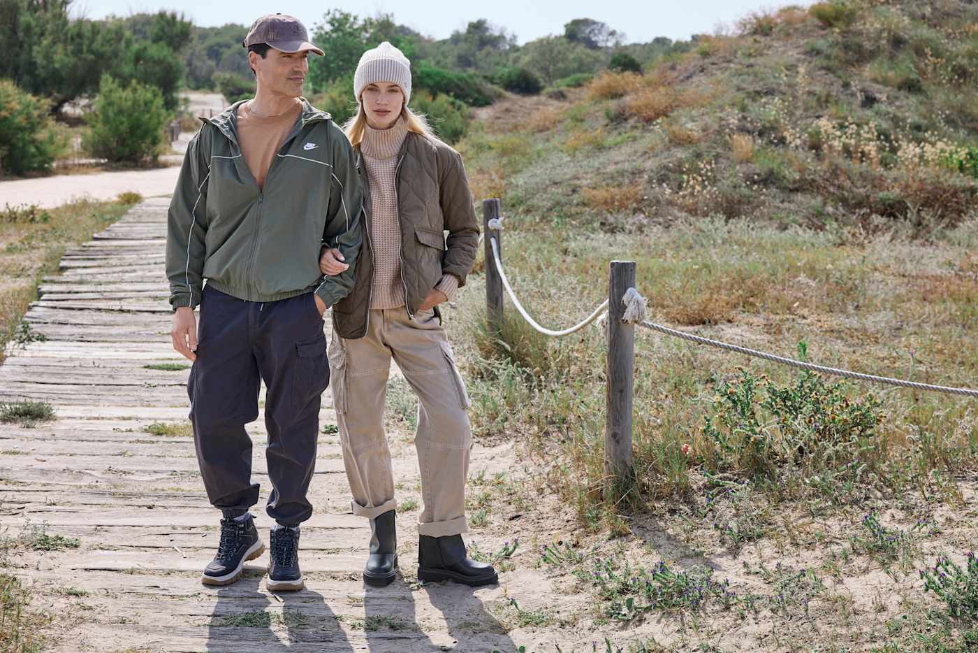 Zwei Personen spazieren in Outdoor-Outfit auf Wanderpfad