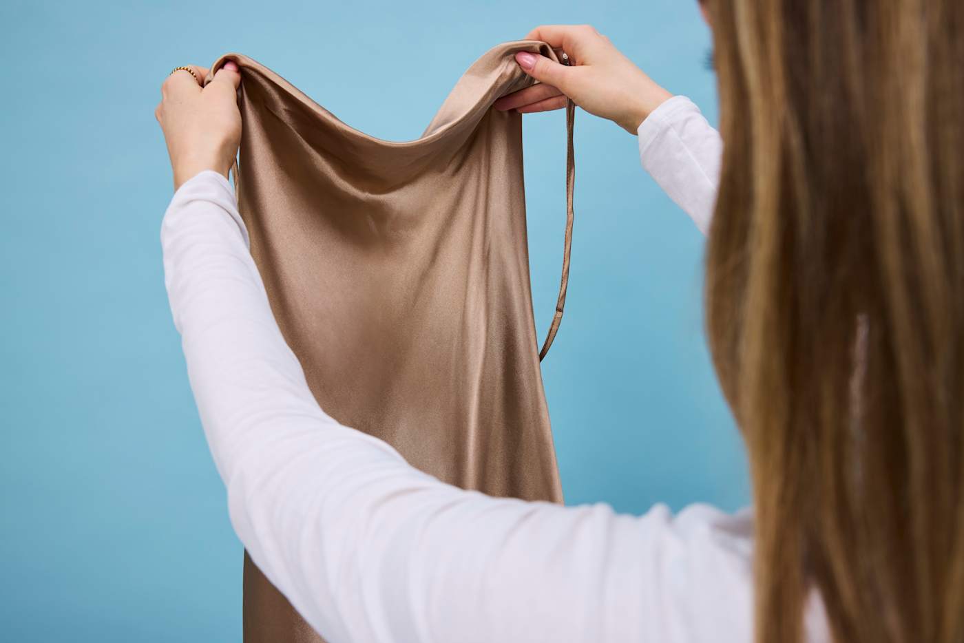 Frau hält ein Kleidungsstück aus Seide bereit für die Wäsche
